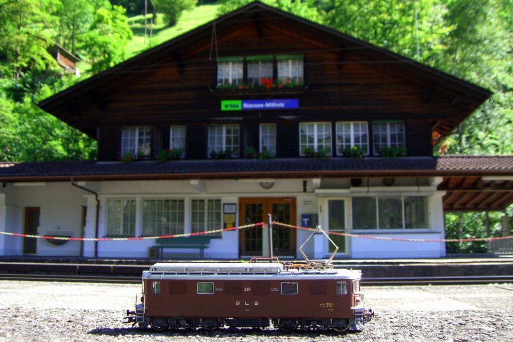 1/87 Roco Modell der BLS Ae 4/4 251 vor dem originalgro�en Bahnhofsgeb�ude von Blausee Mitholz, das es auch als 1/87 Modell von Kibri gibt. (04.08.2007)