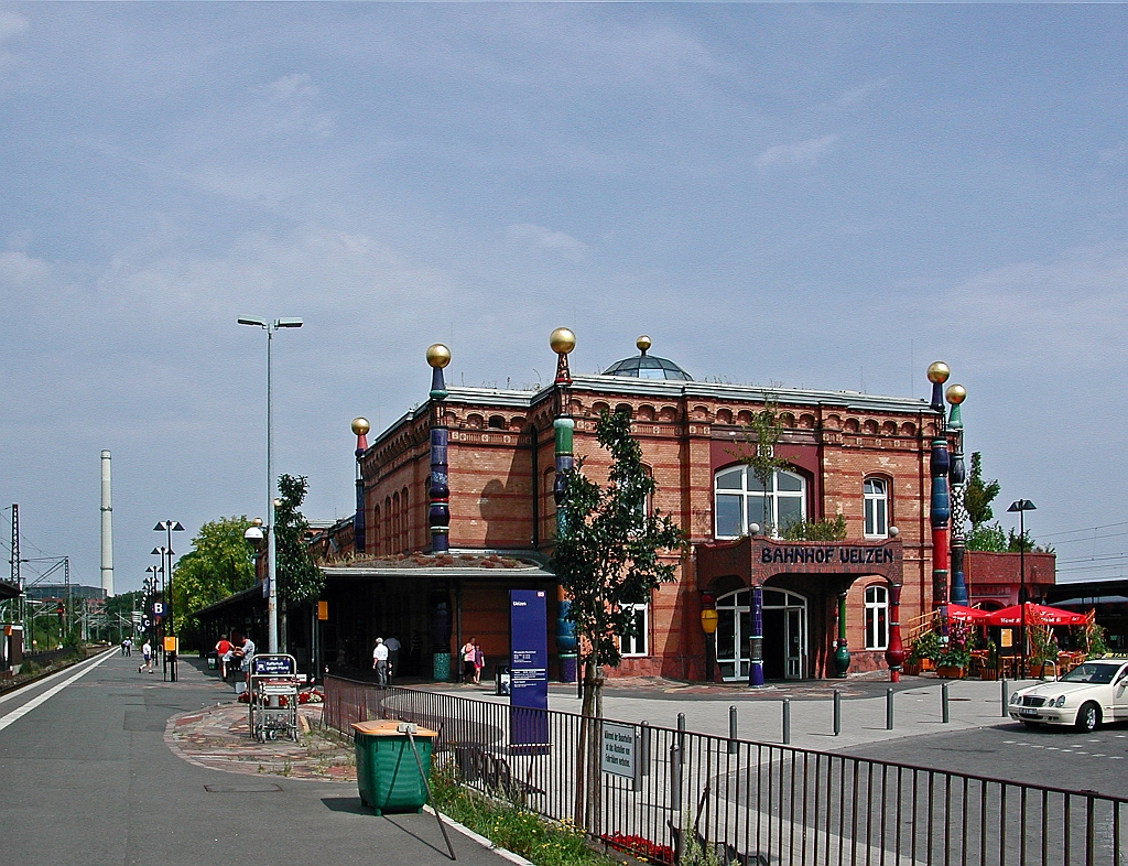Der Bahnhof Uelzen ist ein Kreuzungsbahnhof in Uelzen am Ostrand der L�neburger Heide im Nordosten Niedersachsens.
Das urspr�ngliche Empfangsgeb�ude wurde im Zuge eines Expo 2000-Projektes nach den Pl�nen des �sterreichischen K�nstlers Friedensreich Hundertwasser (Wien) umgebaut. Der Bahnhof wird als „Umwelt- und Kulturbahnhof“ unter dem Namen Hundertwasser-Bahnhof Uelzen vermarktet und ist heute eine Touristenattraktion der Stadt.
Hier das Empfangsgeb�ude am 20.08.2003 von Bahnsteig 101 gesehen.