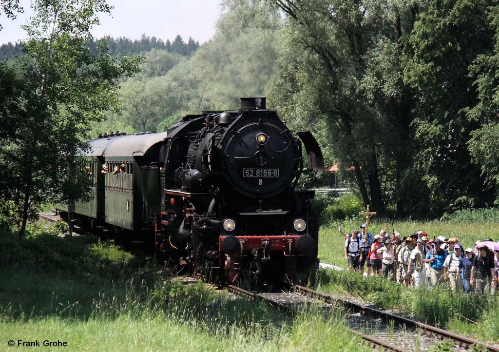 Im Juni letzten Jahres wurde der Abschnitt Landshut - Neuhausen der Strecke Landshut - Neuhausen - Rottenburg nach langj�hriger Pause wieder er�ffnet. 
Die 52 8168-8 vom BEM N�rdlingen befuhr mehrfach die Strecke, hier mit P 3887 nach Landshut, fotografiert bei Weihmichel am 05.06.2011
--> Neben dem Zug bewegt sich gerade eine Fu�wallfahrt zur Gnadenmutter von Alt�tting.