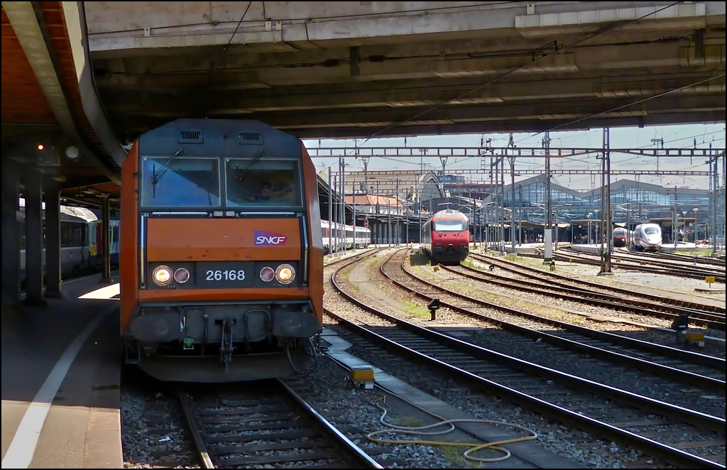 Obwohl das Bild aus Basel SNCF nicht berauschend ist, m�chte ich es aus zweierlei Gr�nden hier zeigen: Rechts im Bild (Basel SBB) ist der ICE zu sehen mit dem Margaretha und Armin am 29.05.2012 nach Hause gefahren sind. Links steht die Sybic BB 26168 mit dem IC (EC) 96  Iris , der uns zur�ck nach Luxemburg gebracht hat. Entstanden ist dieser Zug aus dem TEE  Iris , der fr�her Z�rich mit Amsterdam verbunden hat und der aus finanziellen Gr�nden in den 1980er Jahren aufgegeben wurde. Der Name stammt von der holl�ndischen Nationalblume, der Iris. Die NS waren sp�ter nicht bereit sich an dem neuen Label Eurocity zu beteiligen und deshalb endete der EC Iris in Br�ssel. Der Stauts Eurocity tr�gt der Zug heute nur noch in Belgien. In Frankreich und in Luxemburg wurde er zum IC deklassiert, vor allem bedingt durch das Fehlen eines Speisewagens. In der Schweiz f�hrt er als Interregio. Wir hoffen jedenfalls, dass es den  Iris  noch lange gibt, da er neben dem  Jean Monet  und dem  Vauban  eine direkte Verbindung zwischen Luxemburg und der Schweiz herstellt. (Hans)   