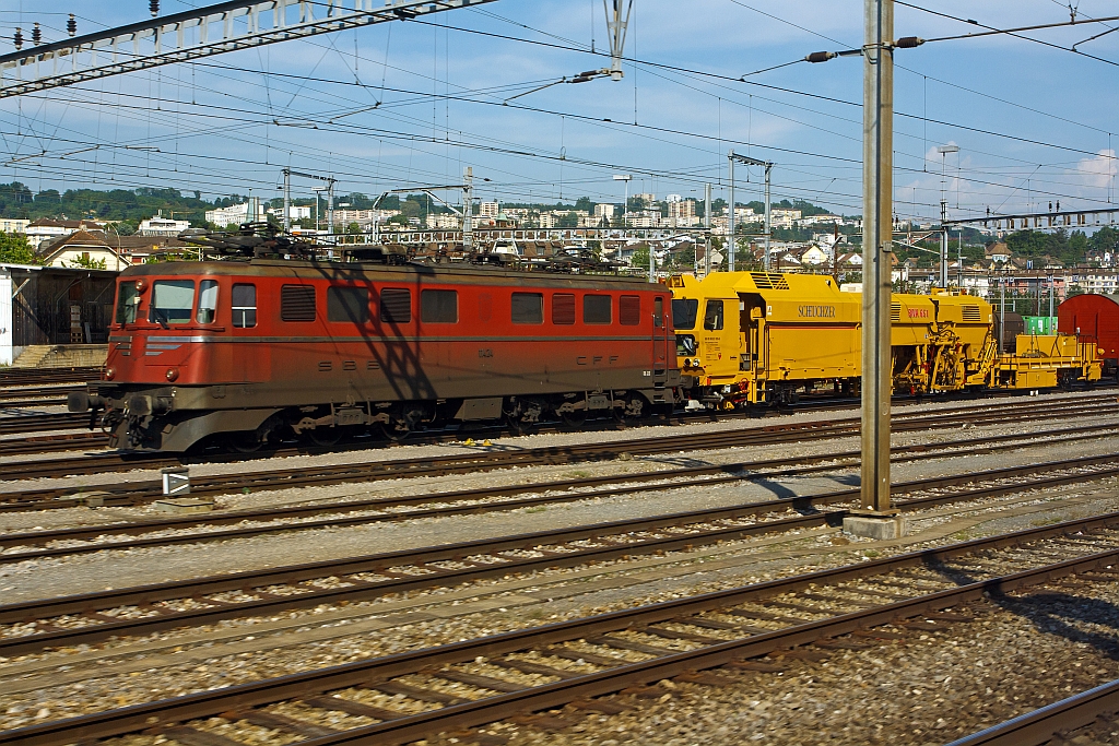 SBB Ae 6/6  (Ae 610)  11424 Kanton Neuch�tel  (leider ohne Wappen) mit einem Bauzug am Haken u.a. eine MATISA Universal-Stopfmaschine BNA 661( SBB 40 85 95 81 035-5), hier am 25.05.2012 beim Bahnhof Lausanne, aufgenommen aus einem fahrenden ICN.