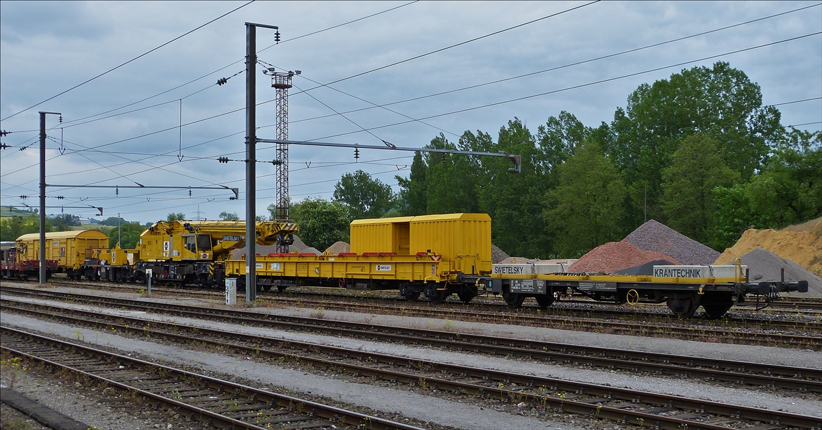 . Der Kirow Gleiskranzug KRC 1200 der Swietelsky Baugeselschaft.mb.H., im Transportmodus, steht am 20.05.2016 im Bahnhofsareal von Ettelbrück.               Der Zug besteht aus: 
1. dem Flachgüterwagen(9100 005-4) vom Typ Us mit der Standartbeladung von 2 Betonblöcken zu je 4,3 t.
2. dem Schutzwagen zu Gleisbaukran KRC 1200, Schweres Nebenfahrzeug (A-RTS 99 81 9377 004-2) auf welchem der Hebearm des Gleiskranes abgestützt ist.
3. Dem Gleisbaukran KIROW KRC 1200, Schweres Nebenfahrzeug (A-RTS 99 81 9119 004-5).
4. Der Gegenlastwagen zu Gleiskran KRC 1200 (99 81 9377 003-4) mit dem  hinteren Gegengewicht des Gleisbaukrans,  und als letztes der Gedeckte Materialwagen  (81 A-RTS 1810 242-9) Typ Gabs, 
5. dem dazugehörende Materialwagen (A-RTS 1810 242-9) vom Typ Gabs.   	          