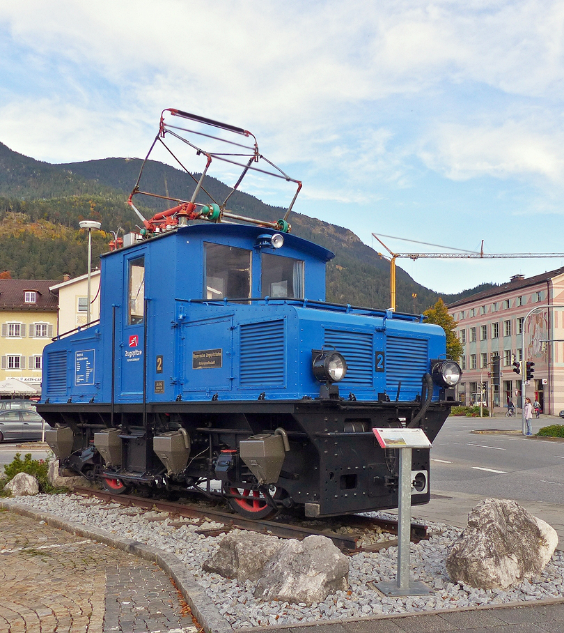 . Die wundersch�ne Tallok N� 2 der Bayerischen Zugspitzbahn steht heute leider nur noch als Denkmal in Garmisch-Partenkirchen. 05.10.2015 (Jeanny)

Die Bayerische Zugspitzbahn ist neben der Wendelsteinbahn, der Drachenfelsbahn und der Zahnradbahn Stuttgart eine von vier noch betriebenen Zahnradbahnen in Deutschland. Die meterspurige Strecke f�hrt vom Garmisch-Partenkirchener Ortsteil Garmisch auf die Zugspitze, den h�chsten Berg Deutschlands. Sie wird von der Bayerischen Zugspitzbahn Bergbahn AG (BZB) betrieben, einer Tochtergesellschaft der Gemeindewerke Garmisch-Partenkirchen. 2007 wurde die Zugspitzbahn f�r die Auszeichnung als  Historisches Wahrzeichen der Ingenieurbaukunst in Deutschland  nominiert.

Zur Betriebser�ffnung 1930 wurden von der AEG zw�lf Lokomotiven geliefert. Darunter vier Tallokomotiven f�r den Adh�sionsabschnitt mit den Fabriknummern 4268 bis 4271 sowie acht Berglokomotiven f�r den Zahnstangenabschnitt mit den Fabriknummern 4260 bis 4267.

Die Talloks bekamen bei der Zugspitzbahn die Betriebsnummern 1 bis 4, die Bergloks 11 bis 18. Die zweiachsigen Tallokomotiven mit der Achsfolge Bo und ihrer Leistung von 2 � 112 kW erreichen maximal 50 km/h. Sie sind 6,9 Meter lang und 27,5 Tonnen schwer.

Mit den lokbespannten Z�gen konnten die Fahrg�ste die gesamte Strecke ohne Umstieg zur�cklegen. Eine Tallok brachte bis zu sechs Personenwagen nach Grainau, dort �bernahmen die Bergloks die Bef�rderung. Unterhalb Eibsee durfte eine Berglok drei, oberhalb Eibsee zwei Personenwagen mitf�hren.

Die technischen Daten der Tallok N� 2:

Baujahr: 1929
Hersteller: AEG Berlin
Achsfolge: Bo
Spurweite: 1000 mm
Antrieb: 2 Tatzlagermotoren � 112 KW = 300 PS Adh�sion
Zugelassene Geschwindigkeit: 50 km/h
Gewicht: 27,5 t
L�nge �ber Kupplung: 6,9 m
Radstand: 3,2 m

