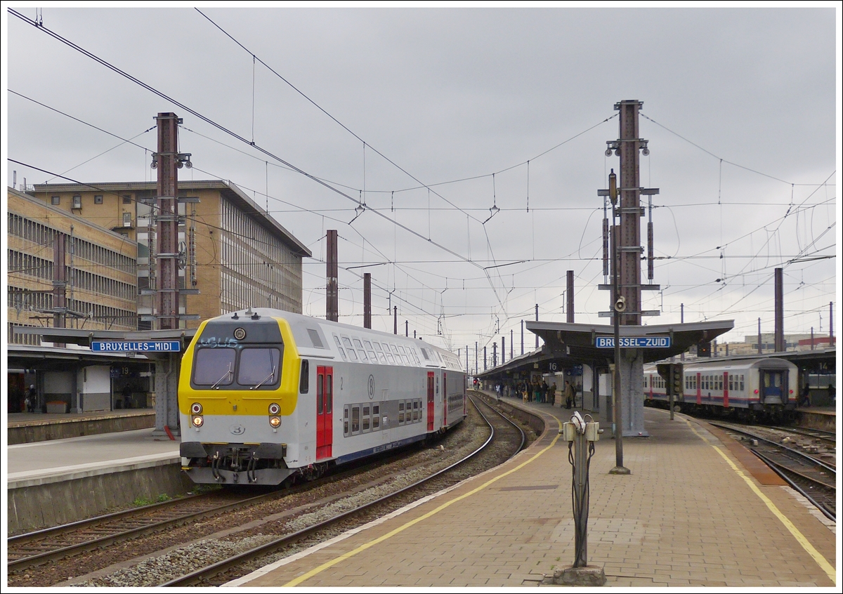 . Ein P (Heure de Pointe = Verst�rkungszug) Zug verl�sst am 10.05.2013 den Bahnhof Bruxelles Midi. Vorne befindet sich ein M 5 BDx (Steuerwagen). Diese Steuerwagen wurden in einer St�ckzahl von 18 in den Jahren 1984 - 1985 gebaut. Vor kurzem wurden sie komplett renoviert und tragen jetzt das �bliche gelb/grau/rote SNCB Design, w�hrend sie anfangs bordeaux rot lackiert waren. Sie sind f�r eine Geschwindigkeit von 140 km/h zugelassen. (Hans)