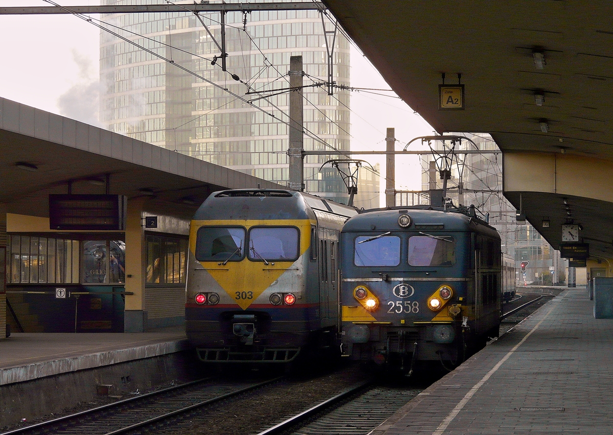. Es war schon recht dunkel am 17.02.2008 im Bahnhof Bruxelles Nord, als die HLE 2558 als Lokzug durch den Bahnhof fuhr, vorbei am Break AM 80 303, welcher am Bahnsteig stand. Der Rauch links im Bild stammt von der Dampflok HLV 64.169 (eine rum�nische P 8) des Museumsvereins PFT/TSP und wenn man genau hinschaut, kann man den Dampfer sogar sehen. ;-) (Jeanny)