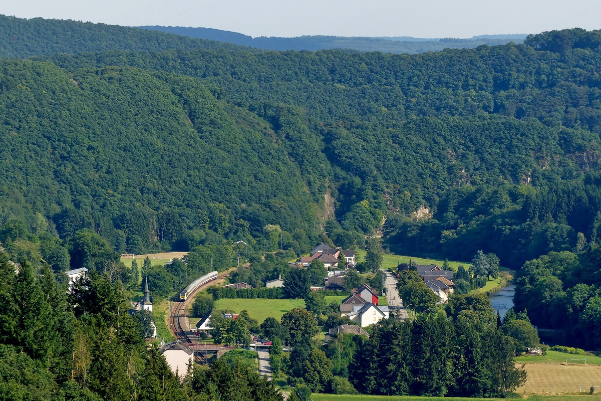 . Gr�nes Sauertal - Im Sommer dominiert die Farbe Gr�n in Michelau, wenn der IR 118 Luxembourg – Liers das Sauertal durchf�hrt. Er hat am 01.08.2014 den Tunnel Michelau verlassen und n�hert sich der Stra�enbr�cke, von welcher aus man eine sch�ne Aussicht auf die Burg Bourscheid hat. Logischerweise bietet die Stra�e etwas unterhalb der Burg ihrerseits einen herrlichen Ausblick auf die Nordstrecke in Michelau. (Jeanny)