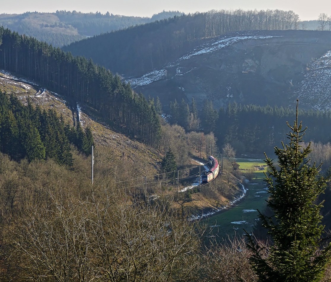 . Suche den Zug - An der Stra�e zwischen Cinqfontaines und Sassel hat man f�r einen kurzen Augenblick eine Aussicht auf die Nordstrecke. Der RE 3814 Luxembourg - Troisvierges f�hrt am 11.02.2015 durch das tiefe Tal der Woltz zwischen Maulusm�hle und Troisvierges. (Jeanny)