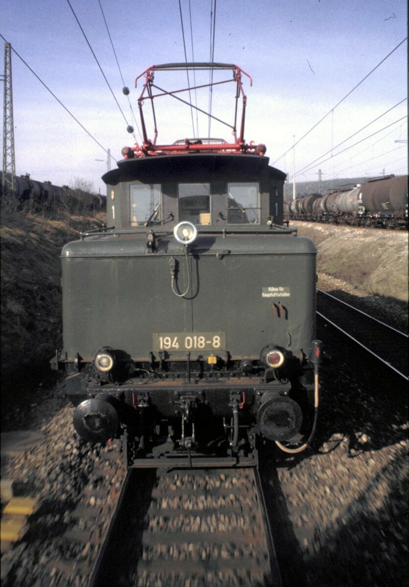 194 018-8 leistet Schubhilfe für einen IC über die Geislinger Steige am 22.11.1982. Die Schublok läßt sich in Amstetten zurückfallen. Für mich hatte es eine kleine Beule eingebracht. Ich hatte nicht bedacht, dass die Kupplungen sich plötzlich straffen und im letzten Wagen ein heftiger Ruck entsteht.