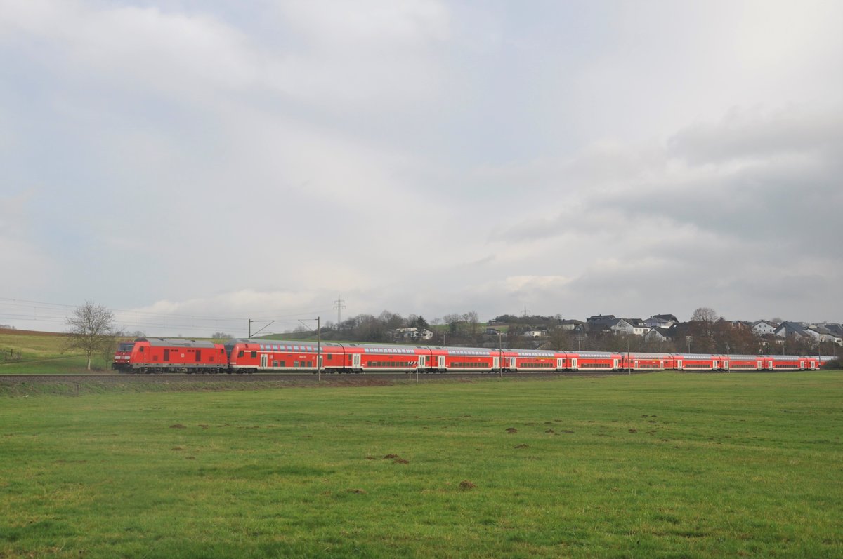 245 020 war am 5. Dezember 2020 mit insgesamt 15 Doppelstockwagen und der schiebenden 143 064-4 auf dem Weg von Frankfurt-Griesheim nach Limburg(Lahn) und wurde dabei zwischen den Orten Oberbrechen und Niederbrechen fotografiert. Grund f�r die �berf�hrung der Fahrt war die Streckensperrung zwischen Idstein(Taunus) und Eppstein aufgrund einer maroden Stra�enbr�cke in Niedernhausen, die akut einsturzgef�hrdet war. Mit einmaliger Erlaubnis durfte die �berf�hrung stattfinden, da zwischen Idstein und Limburg lediglich zwei Garnituren eingesperrt waren, die zum Aufrecht erhalten des Betriebs langfristig gesehen nicht gereicht h�tten. So kam es zu dem ungewohnten Bild, dass sich eine 245 auf die Main-Lahn-Bahn verirrte und eine gro�e Menge an Doppelstockwagen mit sich f�hrte. In Niedernhausen war n�mlich der Strom abgestellt, weshalb man eine Diesellok ben�tigte. 
