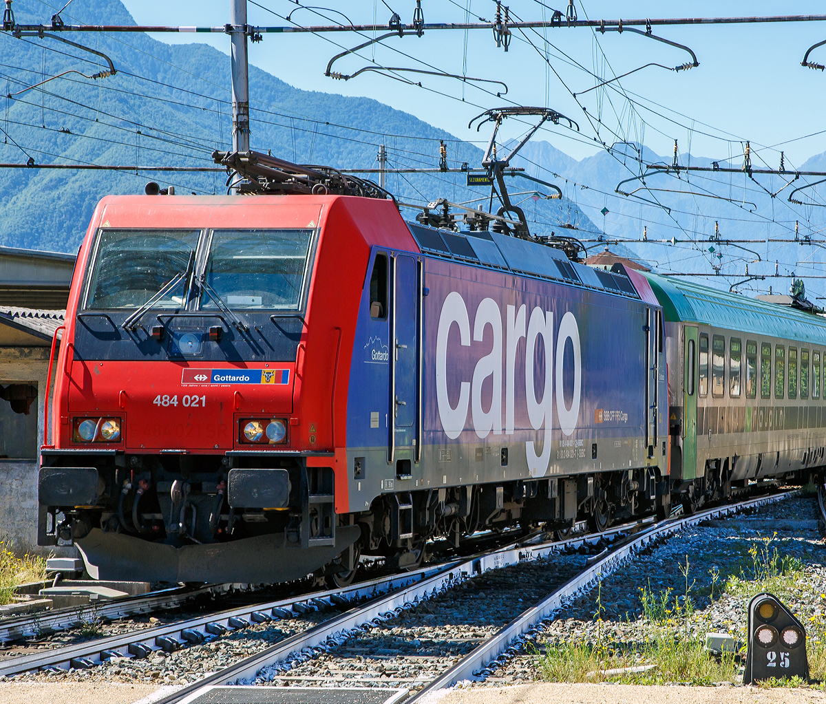 Als Lokportrait……
Die SBB Cargo Re 484 021  Gotthardo  (91 85 4 484 021-1 CH-SBBC / 91 83 2 484 021-7 I-SBBC) kommt am 22.06.2016 mit einem Ralpin-Zug (Rola-Zug) im Bahnhof Domodossola aus Richtung Süden an. Im Domodossola wird sie dann von einer BLS Re 485 (Traxx F140 AC1) abgelöst und den Zug dann, via dem Simplon-Tunnel nach Freiburg im Breisgau bringt.

Die TRAXX F140 MS2 wurde 2006 von Bombardier in Kassel unter der Fabriknummer 34297 gebaut. Sie hat die Zulassung und Zugsicherung für die Schweiz und Italien.

Die Re 484 der Schweizerischen Bundesbahnen (SBB) ist eine Baureihe von Vierstrom-Elektrolokomotiven, die von Drehstrom-Asynchronmotoren angetrieben wird. Die Lokomotiven stammen aus der TRAXX-Familie von Bombardier Transportation und tragen die Herstellerbezeichnung TRAXX F140 MS2.

2003 entschied sich SBB Cargo als erster Betreiber in Europa, die TRAXX-Plattform von Bombardiers (1,5kV / 3kV DC + 15kV / 25kV AC) mit vier Spannungen zu bestellen. Bis dahin existierten diese Maschinen nur auf Papier. Für Bombardier stellte der Auftrag einen solchen Meilenstein dar, dass für die SBB Cargo 484 001, die erste TRAXX-Lokomotive, die auf allen vier wichtigsten europäischen Fahrleitungssystemen eingesetzt werden konnte, die Seriennummer 34000 reserviert wurde.

Die SBB Cargo Re 484-Serie wurde in drei Tranchen ausgeliefert. Der erste Auftrag mit der Re 484 001-012, der im Jahr 2005 abgeschlossen wurden. Im selben Jahr wurde auch der erste Folgeauftrag von sechs Maschinen abgegeben (Re 484 013-018). 2007 wurden drei zusätzliche Maschinen gebaut (Re 484 019-021).
Die Maschinen werden ausschließlich für Dienstleistungen in Italien und der Schweiz seit Lieferung verwendet. Sie verfügen entsprechend über eine 15 kV 16,7 Hz Wechselstromausrüstung (AC) und eine 3 kV Gleichstromausrüstung (DC). Die Umrichteranlage würde auch den Einsatz unter den anderen in Europa verwendeten Stromsystemen 25 kV 50 Hz (AC) und 1,5 kV (DC) erlauben, jedoch ist die Lokomotive nicht mit den dafür notwendigen Zugsicherungssystemen ausgerüstet.

Die Re 484 ist eine Weiterentwicklung der TRAXX-Baureihe F140 AC1 (DB BR 185, SBB Re 482, u. a.), gegenüber welcher sie als augenfälligste Änderung einen überarbeiteten Lokkasten besitzt. Die Änderung erfolgte, um den neuen, strengeren Sicherheitsnormen bezüglich Crashfestigkeit zu genügen. Sie ist am einfachsten an der Lokfront zu erkennen, welche im Bereich der unteren Signalleuchten gerade nach unten verläuft und nicht eingezogen ist wie bei der ersten Serie der BR 185. Außerdem ist unterhalb der Stirnfenster eine Klappe für den Ausbau der Klimaanlage angebracht und die Anzahl der Griffstangen im Frontbereich erhöht worden. Die Lokomotive erhielt auch eine neue wassergekühlte IGBT Umrichteranlage.

TECHNISCHE DATEN:
Spurweite:  1.435 mm (Normalspur)
Achsfolge:  Bo'Bo'
Gebaute Stückzahl:  21
Umgrenzungsprofil: UIC 505-1
Länge über Puffer: 18.900 mm
Virtueller Drehgestellmittenabstand: 10.440 mm
Radsatzabstand im Drehgestell: 2.600 mm
Höhe:  4.283 mm
Breite: 2.977 mm
Dienstgewicht: 85,4 t
Radsatzlast: 21.5 t
Höchstgeschwindigkeit: 140 km/h
Stundenleistung: 5.600 kW
Anfahrzugkraft: 300 kN
Max. elektrische Bremskraft:  240 kN 
Leistung elektrische Bremse:  5.6 MW (bei AC) / 2.6 MW (bei DC)
Treibraddurchmesser:  1.250 mm (neu)/ 1.170 mm (abgenutzt)
Motorentyp:  Drehstrom-Asynchronmotoren
Stromrichter:  2 x MITRAC TC 3300
Anzahl der Fahrmotoren:  4
Antrieb: Tatzlagerantrieb
Stromsystem: 15 kV 16,7 Hz Wechselstrom (AC) und 3 kV Gleichstrom (25 kV 50 Hz AC und 1,5 kV DC wären aber auch möglich)
Anhängelasten: bis 6 Promille 1.950 t, bis 12 Promille 1.620 t und bis 26 Promille 700 t 
Fördervolumen des Kompressors: 2.400 l/min
Hauptluftbehältervolumen: 800 l
Besonderheiten: Automatische Feuerlöschanlage, Rückseheinrichtung (Videokameras)