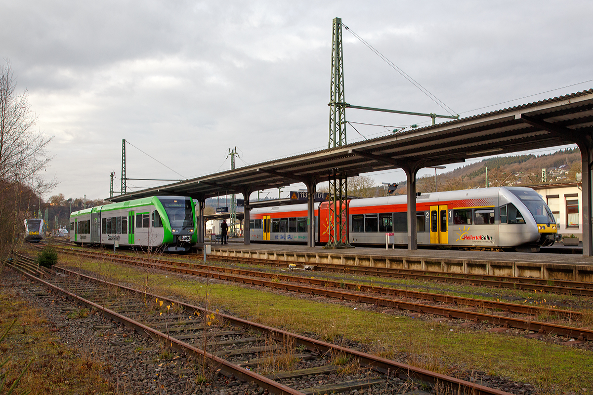 
Anfang und Ende, oder nach dem Ende kommt ein neuer Anfang...
Aber die Stadler GTW 2/6 bleiben ja erhalten...
Betzdorf/Sieg am 12.12.2015

Links steht der VT 526 130 (95 80 0946 430-5 D-HEB / 95 80 0646 430-8 D-HEB / 95 80 0946 930-4 D-HEB) ein GTW 2/6 der HLB (Hessische Landesbahn GmbH), f�r den Fahrplanwechsel am 13.12.2015 in den Startl�chern, er wird dann als RB 96 „Hellertalbahn“ fahren.

In der Mitte (Gleis 113) steht der GTW 2/6 (95 80 0946 418-0 D-WEBA / 95 80 0646 418-3 D-WEBA / 95 80 0946 918-9 D-WEBA) der Westerwaldbahn (WEBA), ex VT 118 der Hellertalbahn, als RB 97  Daadetalbahn   (Betzdorf/Sieg – Daaden), im Bahnhof Betzdorf zur Abfahrt nach Daaden bereit.

Und rechts (Gleis 102) steht der VT 116 (95 80 0646 416-7 D-HEB / 95 80 0946 916-3 D-HEB / 95 80 0946 416-4 D-HEB) ein Stadler GTW 2/6 der HellertalBahn, als RB 96  Hellertal-Bahn  (Betzdorf – Herdorf - Neunkirchen) zur Abfahrt bereit. Er geht auf seine letzte Schicht f�r die HellertalBahn GmbH, die es ab Mitternacht nicht mehr geben wird. Denn nach 16 Jahren wechselt nun der Betreiber, ab den 13.12. wird die RB 96  Hellertal-Bahn  auch von der HLB betrieben.

