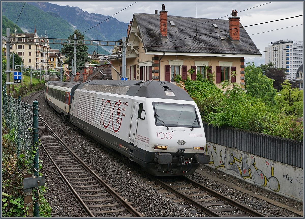 Auch wenn die Hotelgäste ihre Zimmer zum See hin haben, und auf dieser Seite oft nur das Personal haust, bietet sich auch hier der eine oder andere reizende Blick: Die SBB Re 460 113-4  100 Jahre SEV  fährt mit ihrem IR90 nach Genève Aéroport kurz nach der Abfahrt in Montreux an einem schmucken Haus vorbei.

5. Mai 2020