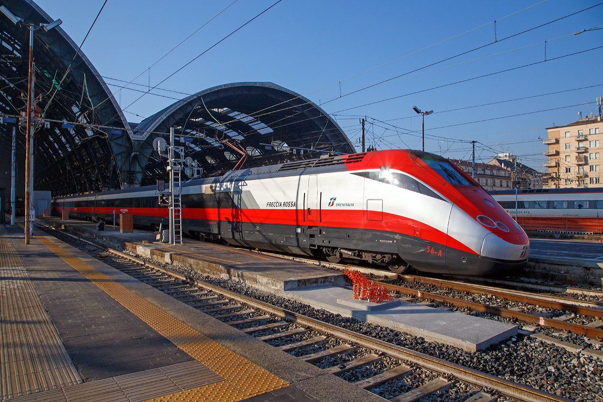 
Ausfahrt eines sehr langen  Frecciarossa  (deutsch: roter Pfeil) der Trenitalia (100-prozentige Tochtergesellschaft der Ferrovie dello Stato) am 29.12.2015 vom Bahnhof Milano Centrale (Mailand Zentral). Der Frecciarossa ist eine Zuggattung für Züge mit einer Höchstgeschwindigkeit von 300 km/h. Hier ist es der ETR 500 - 56 ein ETR 500 der 2.Serie. ETR steht ElettroTreno Rapido.

Diese Züge bestehen aus zwei Triebköpfen vom Typ E.404B und aus zwölf Mittelwagen, ETR 500.31 bis 60 komplett der 2.Serie. Bei den ETR 500.01 bis 30 sind nur die beiden Triebköpfe aus der 2.Serie, die Mittelwagen dagegen stammen aus der 1.Serie der ETR 500 (Mono). 

Durch die begrenzte Stromstärke des Gleichstromnetzes können die Hochgeschwindigkeitszüge nur für Geschwindigkeiten bis zu 250 km/h ausreichend mit Energie versorgt werden. Deshalb entschied sich die italienische Staatsbahn in den 1990er Jahren, weitere Neubau-Schnellfahrstrecken mit Wechselstrom (25 kV, 50 Hz) zu betreiben.

Da die erste Serie der ETR 500 nur für das Gleichstromnetz geeignet ist, wurde ab 1996 eine zweite Serie ETR 500 bestellt und geliefert, die sowohl im Gleichstrom- als auch im Wechselstromnetz fahren kann. Die Zweisystem-Fahrzeuge werden Politensione (deutsch: Mehr-Spannung) genannt. Es gab auch mal zwischenzeitlich Dreisystem-Fahrzeuge (ETR 500 F), die auch unter 1.5 kV DC fahren konnten, diese wurden aber wieder zurückgebaut. Diese waren für den Verkehr nach Frankreich gedacht, bekamen aber dort keine Zulassung.

Die zulässige Höchstgeschwindigkeit der ETR 500 der zweiten Serie von 300 km/h wird im regulären Betrieb aber nur mit Wechselstrom auf neueren Schnellfahrstrecken Italiens erreicht.

Im Gegensatz zur ersten Serie werden bei der zweiten Serie Einholmstromabnehmer verwendet. Die Triebköpfe verfügen jeweils über einen Abnehmer für Gleichstrom und einen Abnehmer für Wechselstrom. Äußerlich unterscheiden sich die beiden Bauserien durch starke Unterschiede des „Gesichts“. Die Front der zweiten Serie wurde aufgelockert und rundlicher gestaltet, besonders betont durch die getrennt angeordneten Spitzensignale, während die Frontscheiben kleiner und rechteckig ausgeführt wurden. Wobei ja die Triebköpfe (E.404A) der ersten Serie zu Lokomotiven der Baureihe E.414 umgebaut wurden.


TECHNISCHE DATEN:
Von einem Triebkopf E.404B
Spurweite: 	1.435 mm (Normalspur)
Achsformel: Bo'Bo'
Länge: 20.250 mm
Höhe: 4.000 mm
Breite: 3.020 mm
Drehzapfenabstand:  11.450 mm
Achsabstand im Drehgestell: 3.000 mm
Dienstgewicht: 68 t
Höchstgeschwindigkeit: 300 km/h
Dauerleistung: 4.400 kW (4 x 1.100 kW) pro Triebkopf
Treibraddurchmesser: 	1.100 mm
Stromsysteme: 3000 V DC und 25 kV 50 Hz AC

Daten der Mittelwagen:
Länge: 26.100 mm
Drehzapfenabstand:  19.000 mm
Achsabstand im Drehgestell: 3.000 mm
Eigengewicht: 40 t

Gesamtzug Daten:
Achsformel: Bo'Bo' (12x 2'2') Bo'Bo'
Gesamtzuglänge: 353.700 mm (bei 12 Mittelwagen)
Gesamteigengewicht: 616 t
Dauerleistung: 8.800 kW
Anfahrzugkraft: 	400 kN
