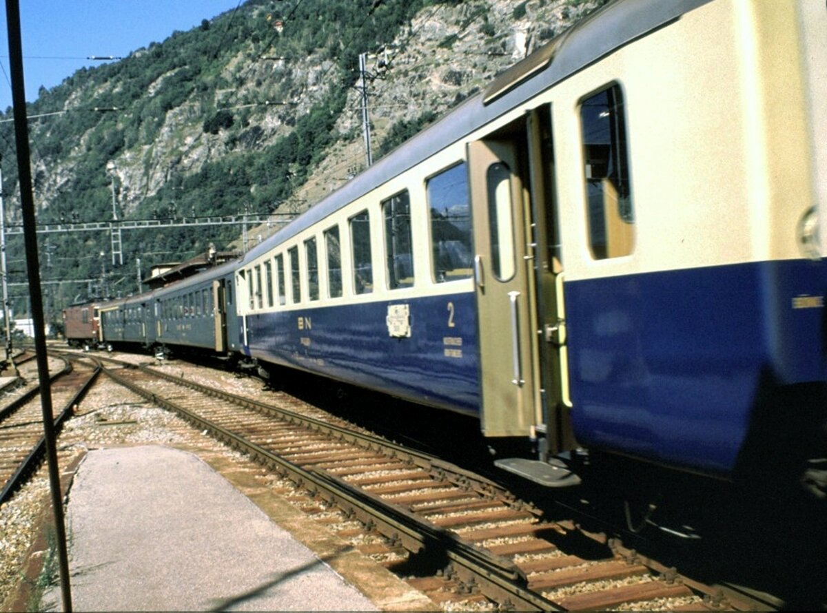 Bei der BLS fährt ein Zug aus Brig aus, bestehend aus Re 4/4 (BLS) und Wagen SBB 1./2. Klasse und SBB 2. Klasse und BN-Wagen 2.Klasse (zur BLS-Gruppe gehörend) rangiert in Brig am 20.08.1979. Bei einigen Wagen sind die Türen geöffnet - ist so etwas heute noch möglich?