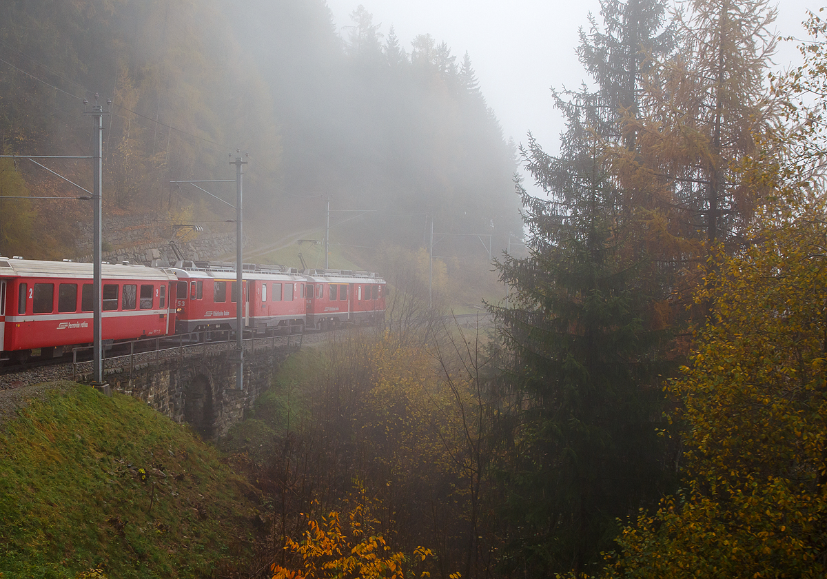 Bei Nebel.....
Geführt von den beiden RhB ABe 4/4 III Triebwagen Nr. 54  Hakone  und 53  Tirano  fährt am 02.11.2019 unser RhB Regionalzug nach Tirano, nun von Cavaglia weiter hinab in Richtung Poschiavo. Hier überquert der Zug den 10 m langen Lehnenviadukt.