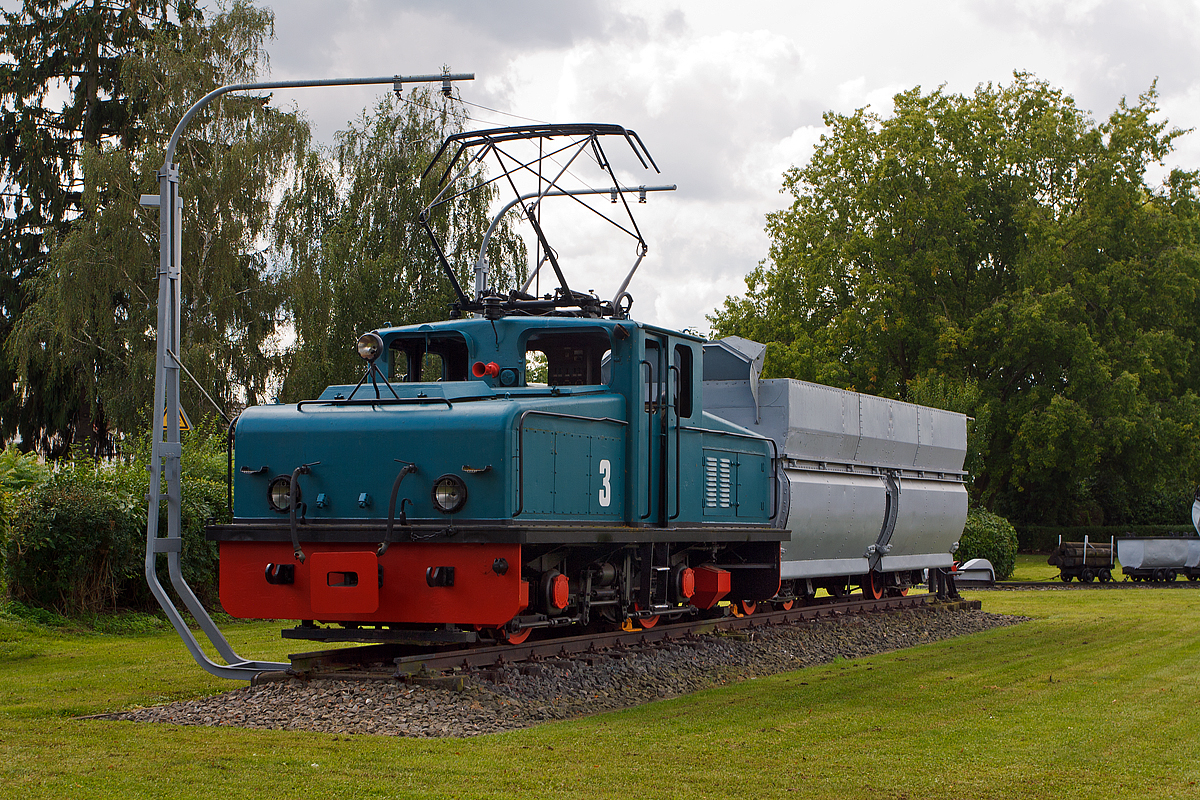 Beim Bahnhof Weckesheim steht als Denkmal die 900 mm ehemalige Lok 3 der Preussen Elektra mit einem Kohlewagen mit Sattelboden für beidseitige Entleerung, hier am 20.08.2014.  Die Lok wurde 1957 von Krupp unter der Fabriknummer  3679 gebaut, der elektrische Teil ist von AEG (Fabriknummer 7498), und an die Hefrag Kohlenbahn (Vorgängerunternehmen der Preussen Elektra) in Wölfersheim ausgeliefert. 

Technische Daten der Lok: 
Achsformel: Bo
Leistung:  360 kW (2x 180 kW)
Gewicht:  33 t
Spurweite:  900 mm
Höchstgeschwindigkeit: 45 km/h

Die PreussenElektra betrieb im 20. Jahrhundert ein Braunkohlekraftwerk in Wölfersheim in der Wetterau. Zur Versorgung des Kraftwerks aus den umliegenden Braunkohletagebauen wurde eine elektrifizierte Schmalspurbahn mit 900 mm Spurweite betrieben. 

Seit den 1980ern wurde dieses Schmalspurnetz schrittweise stillgelegt. 1991 wurde auch der letzte Streckenarm nach Weckesheim eingestellt und diese Lok kam an ihren heutigen Platz.   

Ein Zug, bestand aus einer Lokomotive und sechs mit 150 Tonnen Kohle beladenen Kohlewagen, transportierte die Braunkohle vom Tagebau zur Kohlenmischhalde. Von dort wurde die Kohle über ein Haldenaufnahmegerät und Förderbänder zum Kraftwerk transportiert.