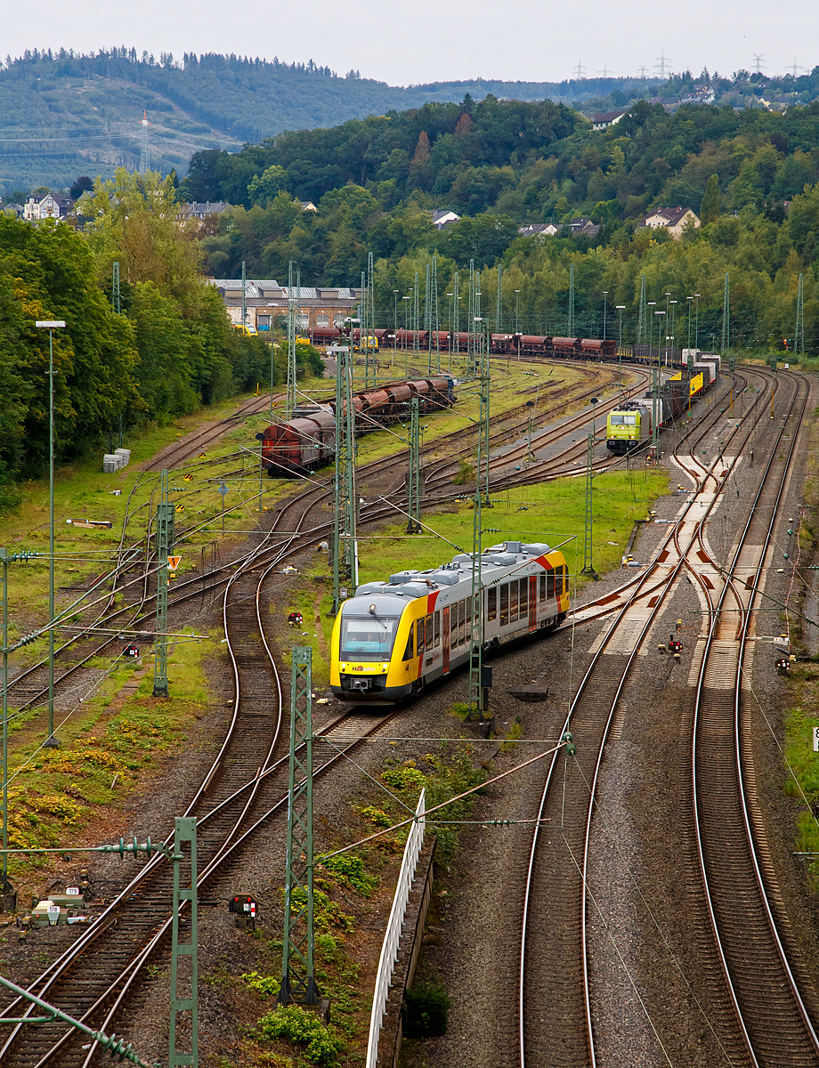 Blick auf den Rangierbahnhof (Rbf) Betzdorf/Sieg (von der Brücke in Betzdorf-Bruche)........
Der VT 263 (95 80 0648 163-3 D-HEB / 95 80 0648 663-2 D-HEB) ein Alstom Coradia LINT 41 der HLB (Hessische Landesbahn), rangiert ungewöhnlich am 20.09.2021im Rbf Betzdorf (Sieg). Im Bereich der Abstellgruppe des Rbf Betzdorf (Sieg) finden z.Z. Bauarbeiten statt.

Hinten hat die α 185 603-8 (91 80 6185 603-8 D-ATLU) einen leeren Güterzug abgestellt. 

Rechts sieht man das zweigleisige Hauptgleis der Siegstrecke.