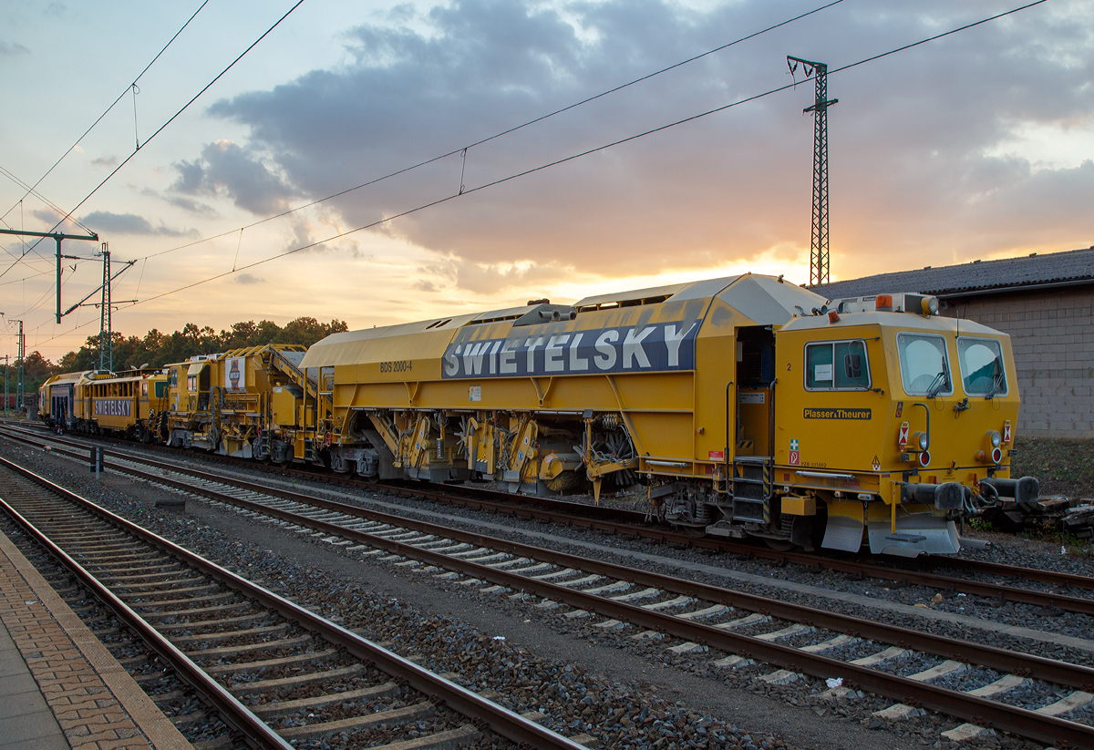 Das Plasser & Theurer  Schotterbewirtschaftungssystem BDS 2000-4 (eine Schotterverteilmaschine), Schweres Nebenfahrzeug Nr. D-RTS 99 80 9125 002-2, der SWIETELSKY Baugesellschaft m.b.H., eigestellt �ber RTS Rail Transport Service GmbH, steht mit einer P&T Unimat 09-32/4 Dynamic am 23.09.2016 im Bahnhof Gie�en.

Das BDS 2000-4 wurde 2011 von Plasser & Theurer  unter der Maschinen Nummer 913 gebaut und an SWIETELSKY geliefert.

Das BDS 2000 bietet die M�glichkeit von Schottermanagement mit h�chster Kapazit�t. Die Ressource Schotter wird damit wirtschaftlich verwendet. Die Maschine ist in ihrer Leistung auf kontinuierlich arbeitende Stopfmaschinen abgestimmt.

Zum Erreichen der n�tigen Hebewerte bei Instandhaltungsarbeiten muss bei jeder Schwelle die passende Schottermenge vorhanden sein. Mit dem BDS 2000-4 kann vorhandener oder vorgelagerter Schotter genutzt und bei Bedarf gezielt verlagert werden.

Das BDS (Ballast Distribution System) nutzt vorhandene Ressourcen auf einzigartige Weise. Im Zuge des Schotterplanierens nimmt es �bersch�ssigen Schotter auf und speichert diesen. Bei Schottermangel wird der gespeicherte Schotter �ber Verteilsch�chte sowie zwei schwenkbare F�rderb�nder im Gleis verteilt. Im Rahmen der Durcharbeitung kann dadurch der Neuschotterbedarf um bis zu 60 % reduziert werden. 

TECHNISCHE DATEN:
Spurweite: 1.435 mm (Normalspur)
Achsanzahl: 8 in 4 Drehgestellen
L�nge �ber Puffer: 40.700 mm
Drehzapfenabst�nde: 11.500 / 7.050 / 14.500 mm
Achsabstand im Drehgestell: 1.800 m	
Eigengewicht: 130,3 t
Zuladung: 40 t
Antriebsleistung: 480 kW	
H�chstgeschwindigkeit Eigenfahrt und geschleppt: 100 km/h
Min. Kurvenradius: 150 m
Zul. Streckklasse: C2 oder h�her
Zur Mitfahrt zugel. Personen: 6
