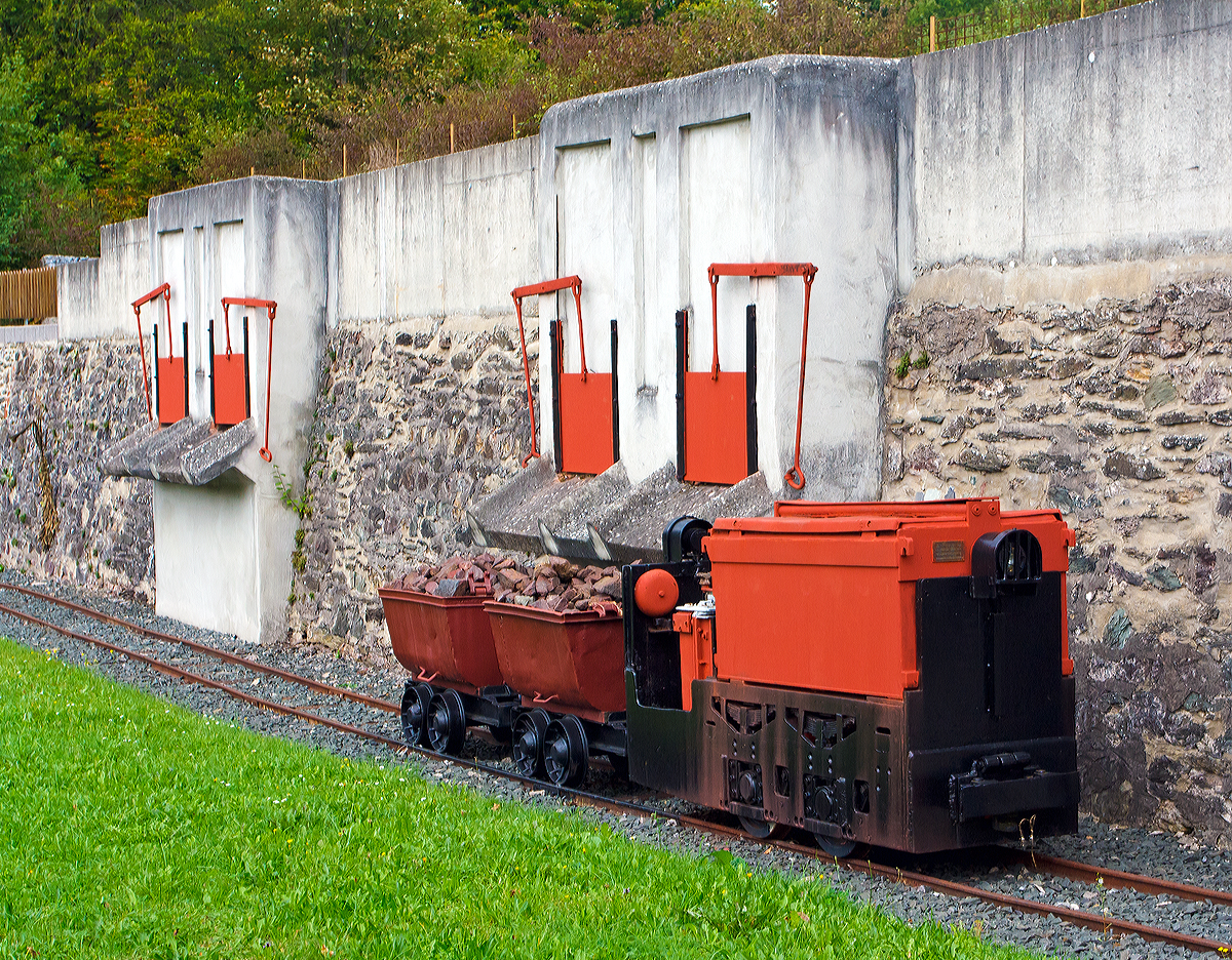 
Denkmal Grubenlok, eine 600mm Siemens-Schuckert-Werke (SSW) Gruben-Akkulok vom Typ GA-Bo-5/17-1, am 20.09.2014 in Weilburg-Ahausen, mit zwei angehängten Loren.
In der Nähe der Lahnbrücke ist die ehem. Verladestelle der ehemalige Erzgrube  Allerheiligen  als schönes Industriedenkmal erhalten worden und diese sowie eine weitere Denkmallok wurden davor platziert. 

Die Akku-Lok wurde 1968 von SSW unter der Fabriknummer 6306 (laut Siemens-LV 6303) gebaut und an das Bergwerk Ewald in Herten (Ewald Kohle AG, ab 1969 RAG) geliefert. Später ging sie zum RAG Maschinen-Übungszentrum in Recklinghausen als Nr. 3, ab 1995 als Museumslok zur Arbeitsgemeinschaft Muttenthalbahn e.V. in Witten/Ruhr  als 52  HEIDI , bis sie 2007 vom Heimatverein Ahausen als Denkmal erworben werden konnte.

Technische Daten:
Typ: SSW GA-Bo-5/17-1
Bauart: Bo – akku
Spurweite: 600 mm
Batterie: Hagen Batterie, 36 Zellen, 500 AH 