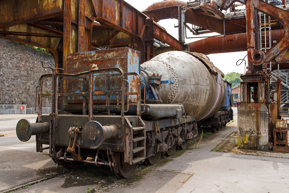 Der achtachsige ATH Thyssen Torpedopfannenwagen T 23 (86002) am 05.06.2011 im LWL-Industriemuseum Henrichsh�tte in Hattingen. Mit 8 Achsen (2 x4) ist dieser Torpedowagen ein recht kleiner Wagen. 

Der Torpedowagen (auch Torpedopfannenwagen oder Roheisenmischerwagen genannt) ist ein Pfannenwagen, dessen Pfanne (der Roheisenmischer) eine an einen Torpedo erinnernde Form hat. Ein langgestreckter Beh�lter mit rundem Querschnitt zwischen zwei Drehgestellen. Die Wagen haben au�er dem Beh�lter selbst keinen Rahmen zwischen den Drehgestellen, damit der Beh�lter m�glichst gro� dimensioniert werden kann.

Die heutigen Hoch�fen besitzen eine untere Etage, durch die direkt Eisenbahnz�ge fahren k�nnen. Das Roheisen rinnt dabei w�hrend des Abstichs in die bereitgestellten Pfannenwagen, die die Form von Zigarren (sogenannte Torpedowagen) besitzen.In den Wagen wird das noch fl�ssige Roheisen zur Weiterverarbeitung zum Konverter ins Stahlwerk bef�rdert.

Damit das �ber 1.400 �C hei�e Roheisen beim Transport nicht zu sehr abk�hlt und die Wagen nicht besch�digt werden, sind die Pfannen im Inneren doppelwandig mit Schamottesteinen ausgekleidet. Bei Fahrten au�erhalb der Werksgel�nde werden zwischen die Pfannenwagen h�ufig leere Flachwagen als Abstandshalter in die Zugkomposition eingef�gt, um eine zu hohe Fl�chenbelastung auf Br�cken zu vermeiden. Auf den Werksgel�nden werden Br�cken m�glichst vermieden bzw. sind  ausreichend stark ausgelegt.

Ein typischer Torpedowagen fasst zwischen 160 und 320 Tonnen fl�ssigen Roheisens, ein Zug besteht aus vier bis sechs solcher Wagen. Torpedowagen lassen sich fest verschlie�en und k�nnen das Eisen wesentlich l�nger fl�ssig halten (bis zu 30 Stunden) als normale Pfannenwagen.
