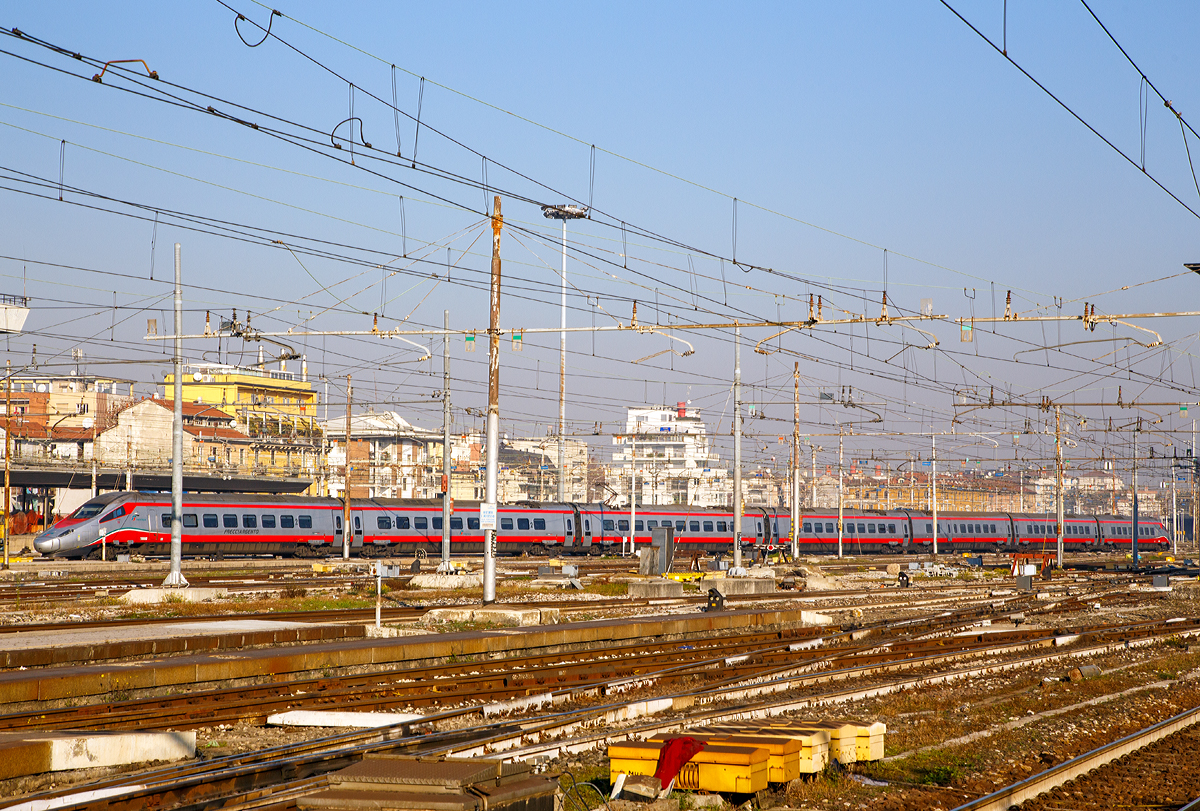 
Der  Frecciargento“  ETR 610.003 der 1. Serie  (93 83 5 610 103-1 I-TI) der Trenitalia (100-prozentige Tochtergesellschaft der Ferrovie dello Stato) am 29.12.2015 bei der Ausfahrt aus dem Bahnhof Milano Centrale (Mailand Zentral). 

Frecciargento (deutsch: Silberpfeil) ist eine  f�r Z�ge mit einer H�chstgeschwindigkeit von 250 km/h. Diese Zuggattung ist eigentlich sehr selten in Milano anzutreffen, da die Z�ge meist den Nordosten Italiens mit dem S�den verbinden, z.B. auf der Strecke Venedig – Bologna – Florenz – Rom.  Die ETR 610 der Trenitalia wurden umlackiert und kamen als Frecciargento im Binnenverkehr zum Einsatz. Seit Dezember 2015 werden jedoch einige davon auf der Gotthardstrecke eingesetzt, wo sie den ETR 470 abl�sten. 

Der ETR 610 (von italienisch ElettroTreno Rapido) ist die Drei-System-Variante des ETR 600. Vier der sieben Wagen eines Zuges werden angetrieben. Eine Zugkomposition besteht aus: Apmt, A, WR, B, B, B und Bpmt. Ein Zug besitzt sechs Stromabnehmer (je zwei f�r ein Stromsystem).

Technische Daten: 
Hersteller: Alstom
Spurweite: 1.435 mm (Normalspur)
Achsformel: (1A)'(A1)' + (1A)'(A1)' + 2'2' + 2'2' + 2'2 + (1A)'(A1)' + (1A)'(A1)' 
L�nge �ber Kupplung: 187.400 mm
Breite: 2.830 mm
Drehzapfenabstand: 19.000 mm
Achsabstand im Drehgestell: 2.700 mm
Treib- und Laufraddurchmesser: 890 mm
Leergewicht: 450 t
H�chstgeschwindigkeit: 250 km/h
Dauerleistung: 5.500 kW
Anfahrzugkraft: 225 kN
Beschleunigung: 0,48 m/s2
Stromsystem: 25 kV 50 Hz und 15 kV 16,7 Hz AC, sowie 3 kV DC
Anzahl der Fahrmotoren:  12
Zugsicherung: ERTMS, SCMT, ZUB, LZB, PZB, Signum
Sitzpl�tze: 431 (1.Klasse 109, 2.Klasse 304 und 18 im Speisewagen)
