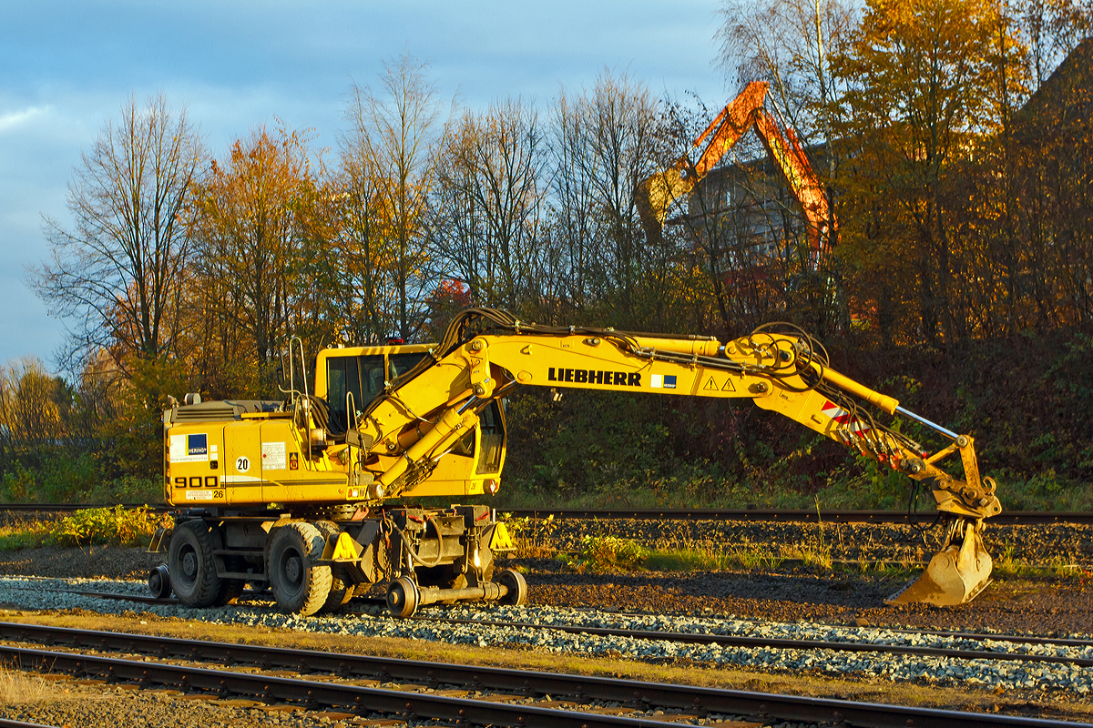 
Der Liebherr A 900 C ZW Li / 1031 Zweiwegebagger (Nr. 26), mit Vier-Punkt-Abst�tzung, der Hering Bau GmbH und Co. KG aus Burbach-Holzhausen beim planieren von Schotter auf den Rangierbahnhof der KSW Kreisbahn Siegen-Wittgenstein (ehem. Freien Grunder Eisenbahn AG) in Herdorf am 06.11.2014. 

Der Zweiwegebagger hat die Kleinwagen-Nr. 97 51 04 511 60-8), er hat ein Eigengewicht von 22,5 t, eine Anh�ngelast von 120 t und eine H�chstgeschwindigkeit von 20 km/h (in Weichen und Kreuzungen beschr�nkt auf 10 km/h), er hat eine Kfz -Bremse und eine Waggonbremsanlage