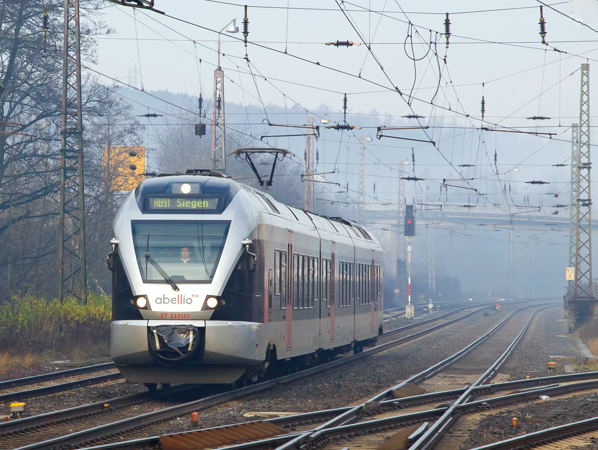 
Der morgendliche Nebel hat sich noch nicht ganz aufgelöst....
Der ET 23 2107 (94 80 0427 106-0 D-ABRN / 94 80 0827 106-6 D-ABRN / 94 80 0427 606-9 D-ABRN), ex ET 23007, ein 3-teiliger Stadler FLIRT der Abellio Rail NRW GmbH, erreicht am 05.12.2015, als RB 91  Ruhr-Sieg-Bahn  (Hagen-Siegen) nun den Bahnhof Kreuztal.