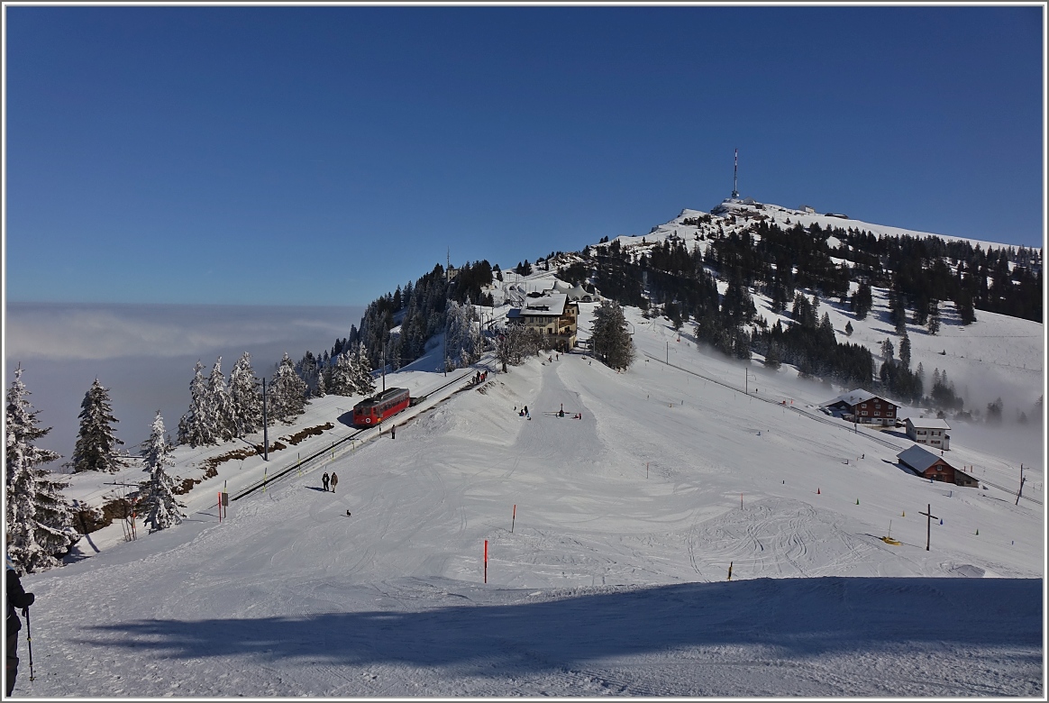 Der RB BDeh 2/4 2 schieb den Kkm 68 Richtung Rigi Kulm und erreicht in Kürze Rigi Staffel.
(24. Februar 2018)