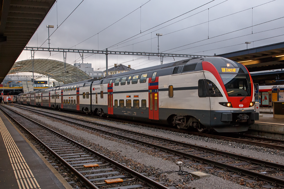 
Der SBB RABe 511 021 (94 85 0 511 021-3 CH-SBB), ein elektrischer sechsteiliger Doppelstock-Triebzug vom Typ Stadler DOSTO bzw. KISS, steht am 17.02.2017 als RE nach Zürich HB im Bahnhof Chur zur Abfahrt bereit. 

Der Stadler DOSTO ist ein elektrischer drei-, vier- oder sechsteiliger Doppelstock-Triebzug von Stadler Rail. Dieser Fahrzeugtyp wurde bis 2010 als „Stadler DOSTO“ bezeichnet und wird seither als Stadler KISS geführt. Den ersten Auftrag für KISS-Doppelstockzüge hate Stadler im Jahr 2008 von den SBB erhalten.

Die SBB haben hauptsächlich für die S-Bahn-Zürich, aber auch für weitere regionale Strecken der SBB, etappenweise (von 2008 bis 2015) 69 sechsteilige (150 m lange) und 24 vierteilige (100 m lange) Doppelstockzüge bei Stadler Rail bestellt.

Die sechsteiligen Züge (wie dieser hier) fassen 1.373 Passagiere, wovon 535 Sitzplätze sind (1. Klasse: 120, 2. Klasse: 415) und erreichen eine Höchstgeschwindigkeit von 160 km/h. Der RABe 511 kann in Vielfachsteuerung mit bis zu 4 Kompositionen verkehren. Angetrieben wird der Zug in den beiden Endwagen auf allen 4 Achsen. Je Fahrzeugseite sind 12 Einstiegtüren (1.400 mm breit) vorhanden. Die Trieb- und Laufdrehgestelle sind alle luftgefedert.

TECHNISCHE DATEN (RABe 511 sechsteilig):
Spurweite: 1.435mm (Normalspur)
Achsformel: Bo’Bo’+2’2’+2’2’+2’2’+2’2’+Bo’Bo’
Länge über Kupplung: 150 m
Höhe: 4.595mm
Breite: 2.800mm
Leergewicht: 297t
Achsabstand im Drehgestell: 2.500mm
Raddurchmesser: 920 mm (neu)
Höchstgeschwindigkeit: 160 km/h
Dauerleistung am Rad: 4.000 kW
Max. Leistung am Rad: 6.000 kW
Anfahrzugkraft: 400 kN (bis 54 km/h)
Beschleunigung: 1,1m/s²
Stromsystem: 15kV 16,7 Hz 
Sitzplätze: 1.Klasse 120 / 2.Klasse 415
Stehplätze (4 Pers/m²): 838 
Einstieghöhe: 555 mm über SOK