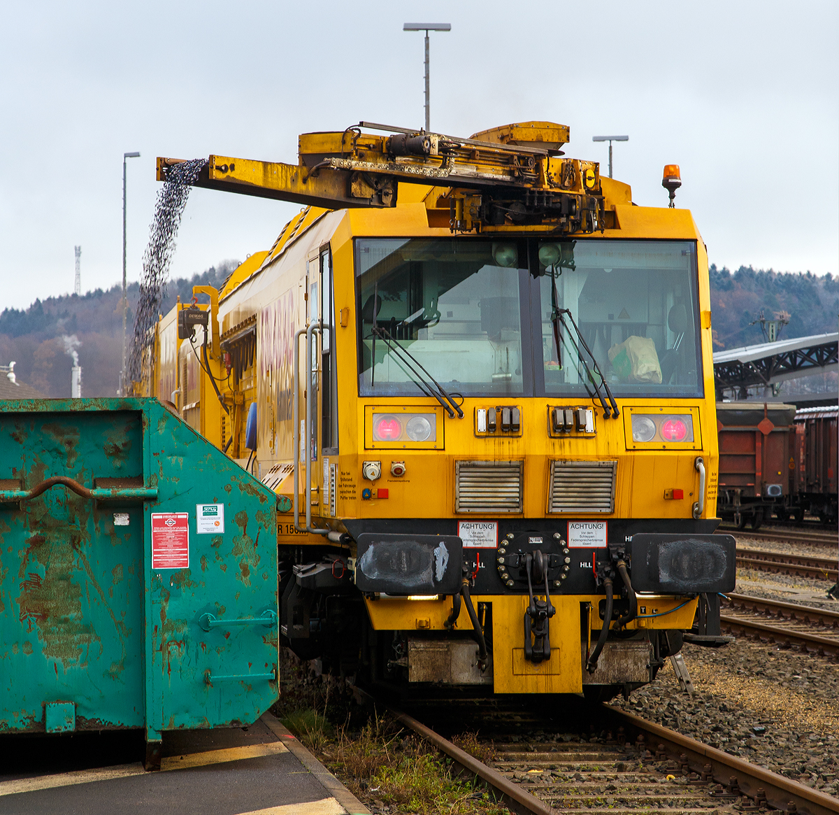 Der Strabag „Hannibal“ ein LINSINGER Schienenfr�szug SF 03 W-FFS, Schweres Nebenfahrzeug Nr. 99 80 9427 003-5 D-BRS der BMTI Rail Service GmbH (Servicebetrieb der STRABAG SE) steht am 01.12.2017 beim ICE-Bahnhof Montabaur, hier laufen die Sp�ne der Nachtschicht in einen Abrollcontainer ab.