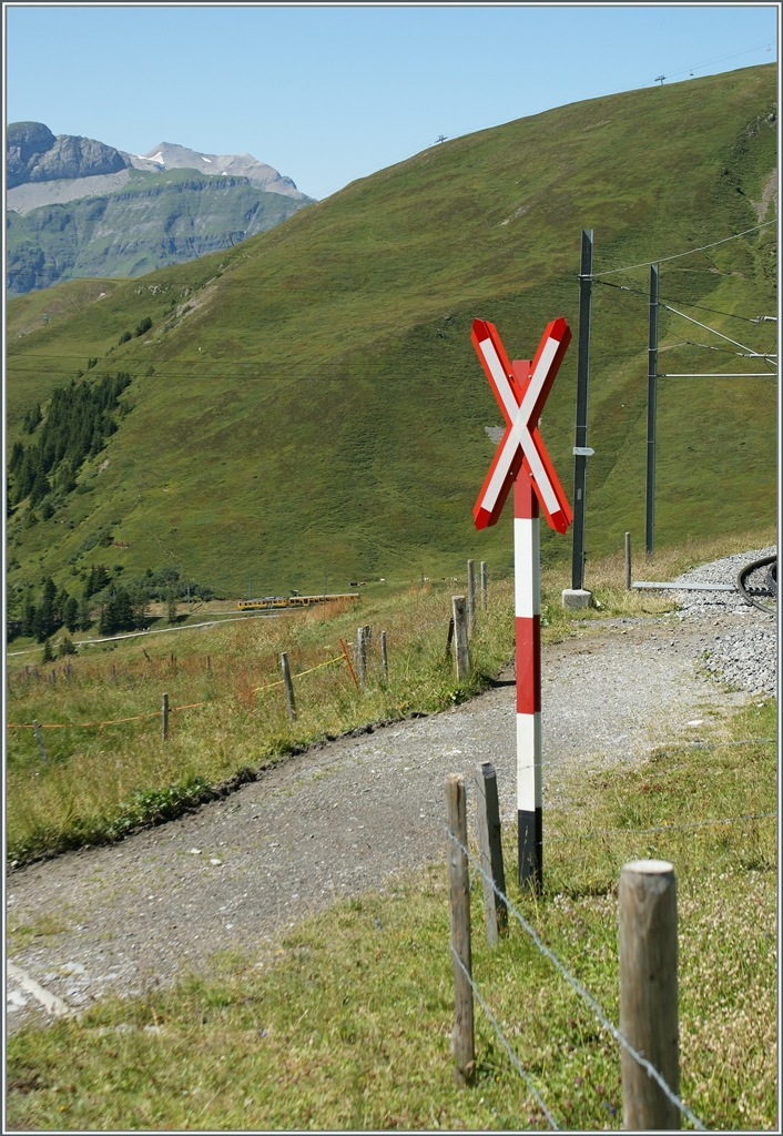 DEr WAB Zug, welcher ganz klein zu sehen ist, wird schon aus Gründen der  Spurweitweite nicht bei diesem sonnenbeschienn Anderaaskreus der JB vorbeifahren können. 
Oberhalb der Kleinen Scheidegg, den 21. Aug. 2013