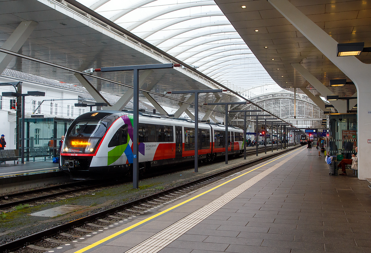 Der zweiteilige Siemens Desiro Classic (Dieseltriebzug) ÖBB 642 136 / 642 636 (95 80 0642 136-5 D-DB / 95 80 0642 636-4 D-DB), steht am 11.09.2022 im Hbf Salzburg, als ÖBB (Salzburg Verkehr) RX 21 Braunau am Inn nach Freilassing, zur Abfahrt bereit. 

Der Desiro Classic wurde 2001 von Siemens in Uerdingen (ex DUEWAG) gebaut, der VT 642 136 unter der Fabriknummer 92018 und der VT 642 636 unter der Fabriknummer 92168.

Seit dem Fahrplanwechsel im Dezember 2019 haben die ÖBB sechs Dieseltriebwagen der BR 642 (642 083, 084, 087, 130, 136 und 204) von der DB Regio Netz Verkehrs GmbH angemietet, diese entsprechen weitgehend der ÖBB Baureihe 5022. Die Triebzüge sind nun in Salzburg beheimatet, sind aber noch in Deutschland registriert und tragen die deutschen NVR-Nummer. Die Wartung erfolgt durch die ÖBB in Salzburg. Die Fahrzeuge werden auf der Mattigtalbahn (Braunau–Salzburg) mit Durchbindung nach Freilassing eingesetzt. 

Hinten sieht man die Integration der denkmalgeschützten Bahnsteigüberdachung in den modernen Glasbau. Man beachte die Stromschiene (Deckenstromschienen DSS System Furrer+Frey) als Oberleitung an den Gleisen 3 und 4. Mit der Erneuerung des schönen Gewölbes über den Gleisen 3 und 4 musste auch die Fahrleitung neu gestaltet werden. Die Architekten haben sich für die Deckenstromschiene entschieden, mit entscheiden war wohl auch die geringere Durchfahrtshöhe unter der denkmalgeschützten Bahnsteigüberdachung. Aber ich finde es sieht wirklich gut aus.

Deckenstromschienen DSS System wurde 1984 von der Schweizer Furrer+Frey AG entwickelt. Seit 1984 liegen auch störungsfreie Betriebserfahrungen vor. Die höchste Betriebsgeschwindigkeit im Tunnel liegt bei 250 km/h, in Versuchen wurden 302 km/h erreicht, aber solche Geschwindigkeit werden im Hbf nicht gefahren.
