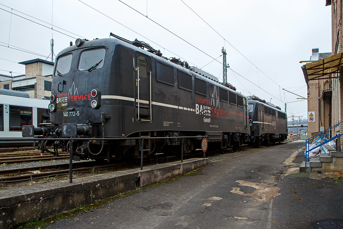 Die 140 772-5 (91 80 6140 772-5 D-EBS) und die 140 789-9 (91 80 6140 789-9 D-EBS) beide der EBS - Erfurter Bahnservice GmbH sind am 25.01.2022 vor der ehemaligen Lokleitung in Siegen beim Hbf Siegen abgestellt.

Lebensläufe der beiden E 40:
Vorne die 140 772-5 wurde 1970 von Henschel & Sohn in Kassel unter der Fabriknummer 31444 gebaut, der elektrische Teil ist von BBC (Brown, Boveri & Cie.) aus Mannheim. Als 140 772-5 wurde sie an Deutsche Bundesbahn geliefert. Im Jahr 1999 wechselte sie in den Geschäftsbereich DB Cargo AG und 2012 ging sie an die DB Tochter RBH Logistics GmbH in Gladbeck als RBH 161 (91 80 6140 772-5 D-RBH). 

Hinten die 140 789-9 wurde auch 1970, jedoch bei Krauss-Maffei AG ind München-Allach gebaut, der elektrische Teil ist von BBC (Brown, Boveri & Cie.) aus Mannheim. Als 140 789.9 wurde sie an Deutsche Bundesbahn geliefert. Auch sie ging 2012 an die DB Tochter RBH Logistics GmbH in Gladbeck als RBH 162 (91 80 6140 789-9 D-RBH). 

Beide Loks gingen 2016 an die EBS - Erfurter Bahnservice GmbH.

Die E 40 der Deutsche Bundesbahn und ab dem Jahr 1968 als Baureihe 140 geführten Loks sind technisch gesehen eine E 10.1 ohne elektrische Bremse, jedoch mit geänderter Übersetzung des Getriebes. Mit 879 Exemplaren ist die E 40 die meistgebaute Type des Einheitselektrolokprogramms der Deutschen Bundesbahn. Ihre zulässige Höchstgeschwindigkeit betrug am Anfang entsprechend ihrem vorgesehenen Einsatzgebiet im mittelschweren Güterzugdienst 100 km/h, diese wurde im Juni 1969 jedoch auf 110 km/h erhöht, um die Züge zu beschleunigen und die Loks auch besser im Personen-Berufsverkehr einsetzen zu können.

TECHNISCHE DATEN:
Spurweite: 1.435 mm
Achsanordnung: Bo´Bo´
Länge über Puffer: 16.440 mm
Drehzapfenabstand: 7.900 mm
Achsstand in den Drehgestellen: 3.400 mm
Gesamtachsstand: 11.300 mm
Treibrad-Durchmesser: 1.250 mm
Dienstgewicht:  86t
Achslast: 21,5t
Zulässige Höchstgeschwindigkeit: 110 Km/h
Stromsystem: Einphasen-Wechselstrom 15 000 V, 16 ²/³ Hz
Nennleistung: 3.700 kW (5.032 PS)
Zugkraft: 336 kN
Nennleistung Trafo: 4040 kVA
Anzahl Fahrstufen:  28
Anzahl Fahrmotoren:  4
Fahrmotor-Typ: SSW WB 372

Beschaffungskosten:  ca. 1.226.000 DM
