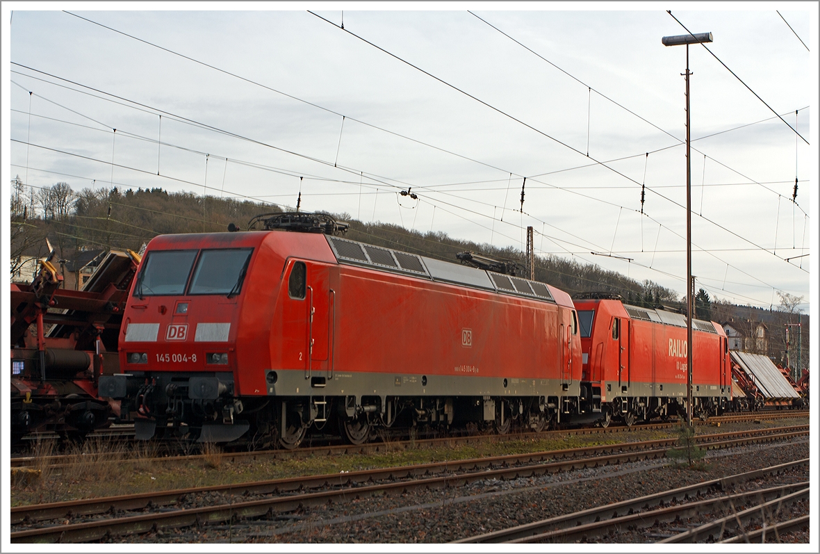 Die 145 004-8 der DB Schenker Rail Deutschland abgestellt am 21.12.2013 in Kreuztal. 

Die TRAXX  F140 AC wurde 1997 bei Adtranz in Kassel unter der Fabriknummer 22298 gebaut, sie hat die NVR-Nummer 91 80 6145 004-8 D-DB und die EBA-Nummer EBA 95T14A 004. 

Dahinter steht die 185 254-0 so kann man gut die Unterschiede zwischen der TRAXX  F140 AC und der F140 AC2 sehen.