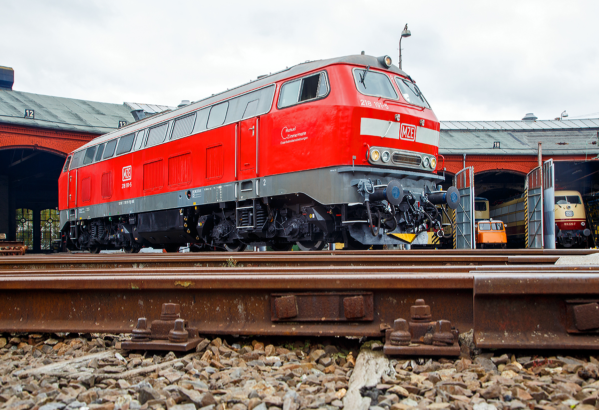 Die 218 191-5 (92 80 1218 191-5 D-MZE) der MZE - Manuel Zimmermann Eisenbahndienstleistungen, Hellenhahn-Schellenberg (Ww), ex DB 218 191-5, am 28.10.2018 auf der Drehscheibe im S�dwestf�lische Eisenbahnmuseum in Siegen. Gerade hat der Lokf�hrer den Motor neu gestartet.

Die V 164 wurde 1973 bei Krupp unter der Fabriknummer 5205 gebaut und an die DB geliefert, im Juli 2018 wurde sie dann ausgemustert und an Manuel Zimmermann Eisenbahndienstleistungen verkauft.

Technische Daten:
Achsformel:  B'B'
Spurweite:  1.435 mm
L�nge: 16.400 mm
Drehzapfenabstand: 8.600mm
Achsabstand im Drehgestell: 2.800mm
Raddurchmesser:1.000mm (neu) / 920 mm (abgenutzt)
Gewicht:  79,5 Tonnen
Radsatzfahrmasse:  20,0 Tonnen
H�chstgeschwindigkeit:  140 km/h
Motor: Wassergek�hlter V 12 Zylinder Viertakt MTU - Dieselmotor vom Typ MA 12 V 956 TB 10 mit Direkteinspritzung und Abgasturboaufladung mit Ladeluftk�hlung
Motorleistung: 1.839 kW (2.500 PS) bei 1500 U/min
Motorhubraum: 114,67 Liter (insgesamt)
Getriebe: MTU-Getriebe K 252 SUBB (mit 2 hydraulische Drehmomentwandler)
Leistungs�bertragung: hydraulisch
Anfahrzugkraft: 235kN (Langsamgang)
Dauerzugkraft: 175kN
Bremse: hydrodynamische Bremse KE-GPP2R-H mZ
Kleinster befahrbarer Gleisbogen: R 100 m
Tankinhalt:  3.200 l

Die Baureihe 218 ist das zuletzt entwickelte Mitglied der V 160-Lokfamilie. Viele Gemeinsamkeiten der Baureihen V 160 bis V 169 (sp�tere 215 bis 219) wurden in ihr zusammengefasst. 

Im Jahr 1966 bestellte die Deutsche Bundesbahn zun�chst zw�lf Vorserien-Lokomotiven der Baureihe V164. Die ersten Lokomotiven wurden ab 1968 von der Firma Krupp ausgeliefert. Von der Deutschen Bundesbahn wurden sie aber als Baureihe 218 in Dienst gestellt. Die Serienbeschaffung (unter Beteiligung von Henschel, Krauss-Maffei und MaK in Kiel) erfolgte von 1971 bis 1979 mit 398 weiteren Maschinen. Hinzu kam 1975 nach einem Unfall die 215 112, die nach ihrer Instandsetzung zur 218 399 wurde. Die Auslieferung erfolgte in vier Bauserien (218 101-170, 171-298, 299-398, 400-499), bei denen es geringe Ver�nderungen gab.
Die 140 km/h schnellen und 2.500 bis 2.800 PS starken ''BB-Loks wurden im Reise - und G�terzugdienst eingesetzt. Die elektrische Zugheizung und die Wendezug- und Doppeltraktionssteuerung machen die Baureihe 218 zu einer universal verwendbaren Lok. Die Baureihe 218 bew�hrte sich im Betriebsdienst und galt noch bis ins Jahr 2000 als die wichtigste Streckendiesellok der Deutschen Bahn AG. Leider wurden immer mehr Leistungen im Personennahverkehr durch Triebwagen ersetzt. Dadurch und durch Betreiberwechsel waren immer mehr Lokomotiven der Baureihe 218 bei der Deutschen Bahn AG �berfl�ssig geworden. Im Juli 2009 waren noch etwa 200 Exemplare im Einsatz. Eine Nachfolgerin f�r die Baureihe 218 ist noch nicht in Sicht.
