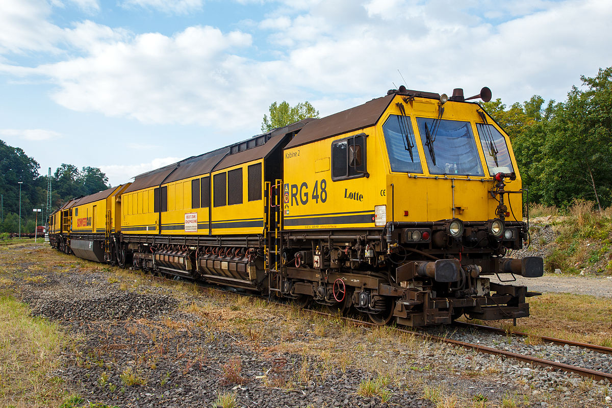 
Die „Lotte“ bzw. die LORAM Schienenschleifmaschine RG 48, Schweres Nebenfahrzeug Nr. 97 33 08 501 17-8, der Schweerbau steht am 18.09.2016 in Betzdorf/Sieg, wo die Tagschicht Wartungsarbeiten durchführt.

Die Schienenschleifmaschine wurde 2002 von LORAM Maintenance of Way, Inc. aus Hamel  / Minnesota (USA) unter der Fabriknummer  LMW001 für die Schweerbau gebaut. Die LORAM Type / Modell Bezeichnung  lautet RG148.

Die Schienenschleifmaschine RG 48 besteht aus drei Wagenteilen, zwei Schleifwagen (1+2) und eine Arbeitswagen dazwischen, die Maschine ist aber eine untrennbare Einheit. Die Schleifwagen ruhen jeweils auf zwei dreiachsigen  Drehgestellen, der Arbeitswagen auf zwei zweiachsigen Drehgestellen.

Die Schleifwagen haben insgesamt 48 Schleifmodule (24 pro Wagen), die elektrisch verstellt werden können, der Anpressdruck geschieht hydraulisch. Die Schleifmotoren  haben eine Leistung von jeweils 22,4 kW. Unter dem Arbeitswagen befindet sich ein Wassertank, mit einem Fassungsvermögen von 25.000 Liter, für Kühl- und Löschwasser. Die Maschinen kann in beide Richtungen arbeiten. Der kleinste bearbeitbare Bogenradius beträgt 180 m. Die Arbeitsgeschwindigkeit ist zwischen 2 und 15 km/h stufenlos einstellbar und abhängig vom Materialabtrag, vorzugweise wir zwischen 8 und 12 km/h gearbeitet. Bei einer Schleifgeschwindigkeit von 8 km/h können 0,25 mm Material angetragen werden. Für das Schleifen des gesamten Schienenkopfes beträgt die Stundenleistung zwischen 700 und 1400 m Gleis.

Die Schienen sind gehören zum wertvollsten Kapital der meisten Eisenbahnen. Die Schnittstelle von Rad und Schiene ist ein anspruchsvolles Thema, vor allem wegen der Kosten zu spät beseitigten Mängel. Typische Probleme auf allen angetroffen Eisenbahnen gehören Schälstellen, Abplatzungen, Seitenverschleiß, getaucht Schweißnähte, Riffen und Ermüdungen, sowie einzigartigen Herausforderungen der Lärmminderung und Fahrqualität.

Das Schienenschleifen gilt als die effektivste Wartung der Praxis, um die Auswirkungen von dem Verscheiß an der Schiene wiederherzustellen.
Zu der Investitionsrendite einer gut gewarteten (frühzeitig geschliffenen) Schiene gehören:
Ein längeres Schienen Leben;
Energie-  Kraftstoffersparnis;
Reduzierter Verschleiß an dem Rollmaterial;
Höhere Achslasten und Zuggeschwindigkeiten und
Verbesserte Fahreigenschaften und Komfort für die Passagiere.

Technische Daten:
Spurweite: 1.435 mm
Anzahl der Achsen: 16 (in 6 Drehgestellen)
Länge über Puffer: 62 325 mm (3 x 20.800 mm)
Drehzapfenabstände: 13.100 mm
Achsabstände in den Drehgestellen der Schleifwagen : 1.500 mm 
Achsabstände in den Drehgestellen vom Arbeitswagen : 1.800 mm
Raddurchmesser: 920 mm
Eigengewicht: 281.500 kg
Achslast: 20,5 t
Zul. Anhängelast: 40 t
Zur Mitfahrt zugel. Personen: 8
Motorleistung: 2x 1.007 KW 
Höchstgeschwindigkeit: 100 km/h
Kleinster befahrbarer Gleisbogen: R 100 m
Zugelassen für Streckenklasse: CE/CM4 und höher
