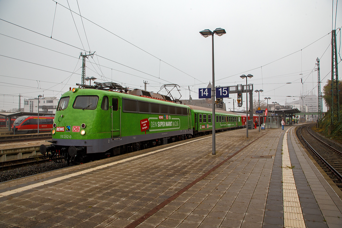 Die B�gelfalten E 10  die 110 292–0 (91 80 6110 292-0 D-GfF) der Gesellschaft f�r Fahrzeugtechnik mbH (bzw. Gesellschaft f�r Eisenbahnbetrieb) steht am 12. und 13.11.2021 (hier 12.11.) mit dem REWE - Supermarkt-Zug im Bahnhof Gie�en.

In Hessen ein zu einem Supermarkt umgebauter Zug in Betrieb genommen worden. Wie die Deutsche Bahn-Tochter DB Regio, der Nahversorger Rewe Region Mitte und der Verein Fairtrade Deutschland mitteilten, werden in dem �Fairen Supermarktzug� k�nftig regionale, �kologische und fair gehandelte Produkte angeboten. Der aus drei Einkaufswaggons, einem Dienstwagen und einem Bord-Bistro bestehende Zug steht an den folgenden Wochenenden (freitags und samstags von 9.00 bis 19.00 Uhr) in den Bahnh�fen Fulda, Kassel, Darmstadt und Wiesbaden. Den �Supermarktzug� f�hren Rewe-Auszubildende.

In Hessen hat Rewe zusammen mit DB Regio eine geniale Idee verwirklicht: Kunden k�nnen hier in einer ganz besonderen Filiale einkaufen. Sie befindet sich im Bahnhof – nicht im Foodcorner, sondern auf der Schiene.

Ach so die Lok hat schon �ber 57 Jahr auf dem Buckel, sie wurde 1964 von Krauss-Maffei in M�nchen-Allach unter der Fabriknummer 18770 gebaut, die Elektrik ist von SSW (Siemens-Schuckertwerke). Sie wurde als E10 292 an die Deutsche Bundesbahn geliefert. Mit der Einf�hrung des EDV-Nummernsystems wurde sie zum 01.01.1968 zur DB 110 292-0, im Jahr 2010 ding sie ins DB-Museum Koblenz-L�tzel, zum 01.01.2021 wurde sie an die GfE Gesellschaft f�r Eisenbahnbetrieb mbH in Crailsheim verkauft.

