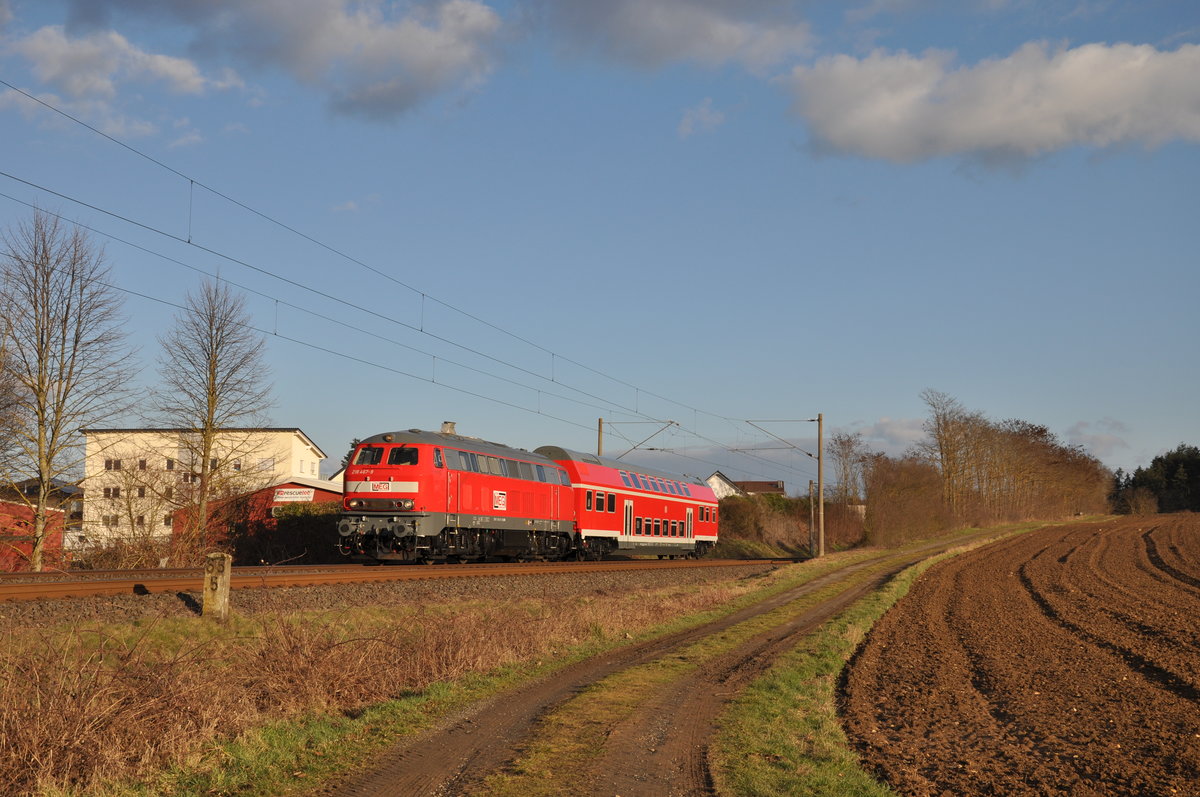Die Bundespolizeischule in Diez bekommt für Übungszwecke einen alten Doppelstockwagen der Deutschen Bahn. Hierbei handelt es sich um den Wagen 50 80 25 - 33 042 - 6 (DBuza 747.4). 
Am 05. März 2021 hatte daher 218 467-9 die Aufgabe, jenen Doppelstockwagen von Apolda nach Diez zu befördern, wo der Wagen dann vier Tage später von einem Schwertransport abgeholt wurde und es zu einem  künstlich angelegten  Bahnhof in der Bundespolizeischule ging. 
Aufgenommen wurde das Bild bei Ennerich, ungefähr 10 Sekunden nachdem sich die Wolken von der Sonne verzogen haben und mir glücklicherweise ein Bild mit Sonne geling.  