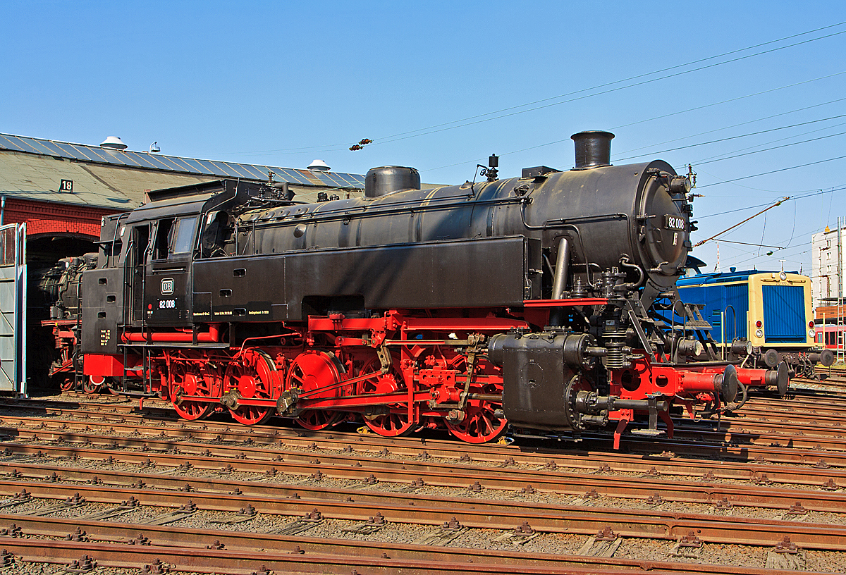 Die DB 82 008 (ex DB 082 008-4) am 23.04.2011 im Südwestfälische Eisenbahnmuseum in Siegen.

Die Lok wurde 1951 bei Krupp in Essen unter der Fabriknummer 2884 gebaut und als 82 008 an die DB geliefert, 1968 wurde sie in DB 082 008-4 umgezeichnet. Die Ausmusterung bei der DB erfolgte am 18.04.1972.

Bis 2014 stand sie (als Leihgabe) im Südwestfälische Eisenbahnmuseum in Siegen, seit April 2014 ist sie nun im DB Museum Koblenz-Lützel zu sehen.

Zum Einheitslok-Typenprogramm der Deutschen Bundesbahn (DB) gehörte auch die fünfachsige Güterzugtenderlokomotive der Baureihe 82. Sie war für den Rangier- und Streckendienst vorgesehen und sollte die fünffach gekuppelten Länderbahnbauarten ablösen, aber auch die durch das komplexe Laufwerk Schad anfällige Einheitslokomotiven der DR-Baureihe 87.

Die Baureihe 82 wurde als erste Neubaulokgattung der DB zwischen 1950 und 1951 von den Unternehmen Krupp und Henschel und in einem weiteren Baulos 1955 von der Maschinenfabrik Esslingen gefertigt.

Bei der Konstruktion versuchte man eine gleichermaßen gut für den Rangier- wie Streckendienst geeignete Maschine zu schaffen. Nach dem bisherigen Stand der Technik widersprachen die für beide Dienste maßgeblichen Konstruktionskonzepte einer gleichwertigen Eignung für beide Dienstbereiche. Dieser Widerspruch sollte durch einen Kessel moderner Bauart und die besondere Laufwerkskonstruktion beseitigt werden.

Um ohne die für eine reine Rangierlokomotive überflüssigen Laufradsätze die für den Streckendienst auch bei höheren Geschwindigkeiten notwendigen sicheren, ruhigen und gleisschonenden Laufeigenschaften zu erhalten, entschied man sich nach Vorversuchen mit einer umgerüsteten preußischen T 16 dazu, das jeweils äußere Kuppelradsatzpaar zu einem Beugniot-Lenkgestell zu vereinigen. Bisherige laufradsatzlose Fünfkuppler-Tenderlokomotiven mit Radsatzanordnung nach Gölsdorf wie etwa die T 16 hatten sich nämlich als für höhere Geschwindigkeiten über rund 40 km/h aufgrund des ausgesprochen unruhigen Laufes als wenig geeignet erwiesen.

Mit den Beugniot-Lenkgestellen waren die Maschinen zugleich ohne die aufwendige Laufwerkstechnik der Baureihe 87 in der Lage enge Gleisbögen (R=100 m), wie z.B. auf der Hamburger Hafenbahn, einwandfrei zu durchfahren.

Bei der Auslegung des Kessels entschied man sich für einen geschweißten Kessel mit großer Strahlungsheizfläche, aber ohne Verbrennungskammer, damit dieser sowohl unter den unregelmäßigen Leistungsanforderungen im Rangierdienst als auch bei Spitzen- und hohen Dauerleistungen im Streckendienst standfest blieb.

Bei der Dimensionierung der Zylinder, die bei einer Rangierlokomotive wegen der aufzubringenden großen Kräfte mit kleinem Durchmesser, bei einer Streckenlokomotive hingegen zur Ausnutzung der Dampfdehnung großvolumig auszulegen gewesen wären, entschied man sich für einen Kompromiss. Dieser führte allerdings, wie vom Bauartdezernenten Friedrich Witte vorhergesagt, zu einem erhöhten Brennstoffverbrauch. Im Rangierdienst schwankte der Mehrverbrauch zur T 16 um 10 bis 19 %, im Streckendienst sogar um 30 %.

Beim Laufwerk wurde nur der dritte Treibradsatz, fest im Rahmen gelagert. Die beiden jeweils außen liegenden Kuppelradsatzpaare verband man mit Beugniot-Hebeln zu jeweils einem Lenkgestell. Die Endradsätze waren um insgesamt 52 mm seitlich verschiebbar, der zweite bzw. vierte Kuppelradsatz noch um insgesamt 36 mm.

Die Lokomotiven der Baureihe 82 bewältigten eine Wagenzugmasse von 800 t in der Ebene mit 70 km/h. Auf Steigungen von 10 Promille konnten noch 400 t mit 40 km/h befördert werden.

Belegt sind Einsätze vor allem auf den Rangierbahnhöfen in Bremen und Hamm sowie den Hafenbahnen von Emden und Hamburg. Im Streckendienst konnten die 82er auf den Steilrampen Siegerland und Westerwald und im Schwarzwald auf der Murgtalbahn beobachtet werden.

Neben einem hohen Schmierölverbrauch bemängelte der Betriebsdienst an der Baureihe 82 vor allem außer den problematischen Heißdampfreglern und schlecht funktionierenden Strahlpumpen einen raschen, durch Verschmutzung bedingten, Verschleiß der Lenkgestelle.

Die Ausmusterung begann bereits 1966, Auslauf-Bw war Koblenz-Mosel, wo die letzte Maschine dieses Typs 1972 abgestellt wurde. Die Baureihe war damit früher aus dem Dienst geschieden als die Baureihe 94, welche sie ja ersetzen sollte.
Fast alle Lokomotiven dieser Baureihe wurden nach Einsatzende verschrottet, lediglich die hier gezeigte 82 008 stellte man 1974 als Denkmal am Bahnhof Lingen (Ems) auf, sie gelangte so in den Bestand des DB Museums. Nach Stationen in Neumünster (2003-2010) und Siegen (2010-2014) befindet sie sich nunmehr im DB Museum Koblenz.


Technische Daten der Baureihe 82:
Gebaute Anzahl: 41 (DB 82 001 - 041)
1435 mm (Normalspur)
Achsformel / Bauart:  E h2t
Gattung:  Gt 55.18
Länge über Puffer:  14.060 mm
Höhe:  4.450 mm
Gesamtachsstand:  6.600 mm
Leergewicht:  69,7 t
Dienstgewicht:  87  t
Achslast:17,4 t
Höchstgeschwindigkeit:  70 km/h (vorwärts / rückwärts)         
Leistung:  1.290 PSi (949 kW)
Treibraddurchmesser:  1.400 mm
Steuerungsart:  Heusinger
Zylinderanzahl:  2
Zylinderdurchmesser : 600 mm
Kolbenhub:  660 mm
Kesselüberdruck:  14 bar
Anzahl der Heizrohre:  113
Anzahl der Rauchrohre:  38
Heizrohrlänge:        4.000 mm
Rostfläche:   2,39 m2
Überhitzerfläche:  51,90 m2
Verdampfungsheizfläche:   122,21 m2
Kohlenvorrat:   4 t
Wasservorrat:  11 m3
Seit 1960 ist die 82 008 mit einer Riggenbach-Gegendruckbremse ausgerüstet.

Quellen: wikipedia, eisenbahn-museumsfahrzeuge.de