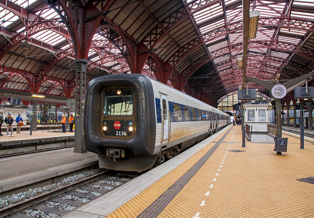 
Die DSB Gumminase bzw. DSB IR4 – ER2136, FR 2336, FR 2236 und ER 2036, steht am 20.03.2019 abfahrtbereit im Hauptbahnhof Kopenhagen (K�benhavns Hovedbaneg�rd).

Die DSB-Baureihe ER (in D�nemark als IR4 bezeichnet) sind vom Hersteller ABB Scandia gebaute vierteilige Elektrotriebz�ge f�r die Danske Statsbaner (DSB). Sie wurden konzeptionell aus dem Dieseltriebzug der Baureihe MF weiterentwickelt. 

Ein Triebzug besteht aus vier Wageneinheiten: ein Motorwagen ER (2001–2044) mit Stromabnehmer, zwei Mittelwagen FR (2201–2244 und 2301–2344) sowie ein weiterer Motorwagen ER (2101–2144) ohne Stromabnehmer. Sie l�uft auf insgesamt f�nf Drehgestellen (davon drei Jakobs-Drehgestelle) mit der Achsfolge Bo’2’2’2’Bo’ und wird von vier Elektromotoren mit je 420 kW angetrieben.

Die Einheiten der Baureihe ER k�nnen mit den dreiteiligen Dieseltriebz�gen der Baureihe MF vielfachgesteuert im Verband gefahren werden. Die Besonderheit beider Baureihen ist ein wegklappbarer F�hrerstand, der zu einem Durchgang umfunktioniert werden kann. Auf diese Weise lassen sich maximal f�nf ER- bzw. MF-Einheiten zu einem durchg�ngigen Zug kombinieren. Das Verbinden mehrerer Einheiten erfolgt �ber automatische Scharfenbergkupplungen. Der Wagen�bergang ist dank des Gummiwulstes zugluftdicht. Die Triebz�ge sind mit dem Zugbeeinflussungssystem ATC f�r D�nemark ausgestattet.

Die Elektrotriebz�ge wurden urspr�nglich f�r den regionalen Verkehr auf den elektrifizierten Strecken im Raum Kopenhagen entwickelt und wurden daher gegen�ber der f�r den Fernverkehr entworfenen Diesel-Baureihe MF einfacher ausgestattet. Sp�ter wurde das Einsatzgebiet jedoch um die elektrifizierte Fernstrecke Kopenhagen–Odense–Fredericia–S�nderborg erweitert und die Innenausstattung auf das Niveau der Baureihe MF aufgewertet.

TECHNISCHE DATEN:
Anzahl: 44 St�ck
Hersteller: ABB Scandia
Baujahre: 1993–1997
Spurweite: 1.435 mm (Normalspur)
Achsformel: Bo’2’2’2’Bo’
L�nge �ber Kupplung: 76.530 mm (20.530 / 17.730 / 17.730 / 20.530 mm)
Breite: 3.100 mm
H�he: 3.850 mm
Dienstgewicht: 133 t
H�chstgeschwindigkeit: 180 km/h
Leistung: 1.680 kW (4 x 420 kW)
Stromsystem: 15 kV 16,7 Hz ~
Kupplungstyp: Scharfenbergkupplung
Sitzpl�tze: 24 (1. Klasse), 183 (2. Klasse)
Klappsitze: 20
Fu�bodenh�he: 1.300 mm
