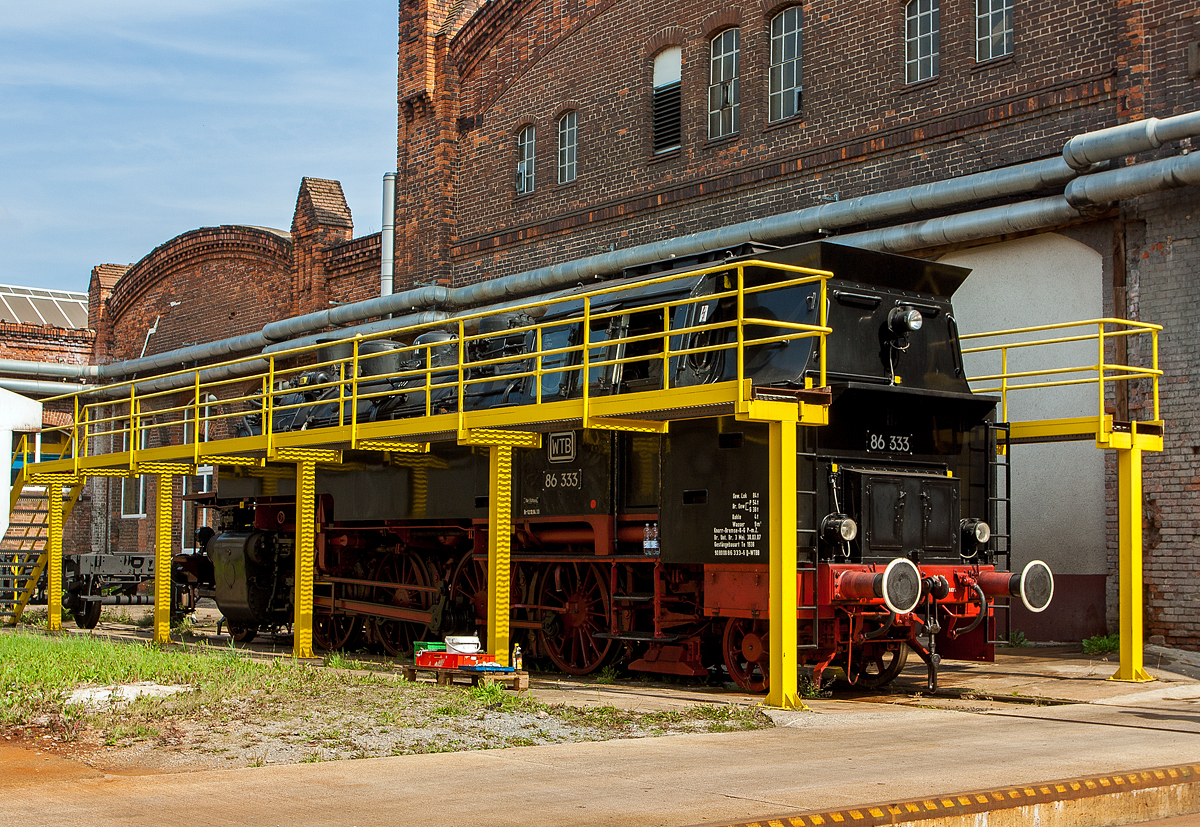 Die Einheits-Güterzugtenderlokomotive  86 333, ex DR 86 1333-3, ex DR 086 333-2, (damals 2013) der WTB - Wutachtalbahn e.V. steht am 24.08.2013 im Dampflokwerk Meiningen (DLW).

Die 1D1-Tenderlokomotive (vierfach gekuppelte Tenderlokomotive) wurde 1939 von der WLF - Wiener Lokomotivfabrik Floridsdorf unter der Fabriknummer  321gebaut. Seit 2007 besitzt sie einen, vom DLW - Dampflokwerk Meiningen 2006 unter der Fabriknummer 1536, gebauten Neubaukessel.

Nach dem Krieg blieb sie im Osten und kam zur DR - Deutsche Reichsbahn. Ihr wechselvoller Lebenslauf bei der Deutschen Reichsbahn führte die Lok durch zahlreiche Betriebswerke Mitteldeutschlands. Die längste Verweildauer hatte sie in den Betriebswerken Chemnitz und Glauchau. Im Jahr 1970 erfolgte die Umzeichnung in 86 1333-3, im Jahr 1992 wurde sie als 086 333-2 geführt. 

Weitere Lebenslauf und Eigentümer:
1993-1995  EVG - Eisenbahnverkehrsgesellschaft, Aalen  als 86 333 
1995-1997  BEM - Bayrisches Eisenbahnmuseum Nördlingen 
1997-2015 86 333 WTB - Wutachtalbahn e.V. , von 2007 bis 2013  als 90 80 0086 333-2 D-WTBB, von 2013 bis 2015 als 90 80 0086 333-2 D-DBFZI
2015 wurde die Lok an die PRESS, Eisenbahn-Bau- und Betriebsgesellschaft Pressnitztalbahn mbH verkauft und wird als 86 1333-3 (90 80 0086 333-2 D-PRESS) geführt.

Die Baureihe 86 wurde als Einheits-Güterzugtenderlokomotive von der Deutschen Reichsbahn entworfen. Sie war für den Einsatz auf den Nebenstrecken vorgesehen und wurde von fast allen für die Deutsche Reichsbahn tätigen Unternehmen geliefert. Die ersten Lieferungen (wie diese hier) waren noch mit Bissel-Laufachsen ausgerüstet, die Maschinen mit den Betriebsnummern 86 293-296 und ab der Nummer 86 336 erhielten aber dann Krauss-Helmholtz-Gestelle. Dadurch konnte die Höchstgeschwindigkeit von 70 auf 80 km/h heraufgesetzt werden, die Gesamtlänge wuchs auf 13.920 mm. Ab 1942 wurde sie in einer vereinfachten Form als Übergangskriegslokomotive (ÜK) gebaut. Im Zeitraum von 1928 bis 1943 wurden 775 Exemplare gebaut, von denen alle bis auf zwei Maschinen nach dem Zweiten Weltkrieg wieder aufgefunden wurden.

385 Maschinen verblieben auf dem Netz der Deutschen Bundesbahn in Westdeutschland, wovon 8 Lokomotiven wegen Kriegsschäden bis 1952 ausgemustert wurden. Die Deutsche Reichsbahn konnte nach Abgabe von 71 Loks an die Sowjetischen Eisenbahnen (SŽD) von dann noch vorhandenen 172 Exemplaren 164 in den Betriebsbestand aufnehmen.

TECHNISCHE DATEN (dieser Lok bzw. der ersten Serien):
Spurweite: 	1435 mm (Normalspur)
Achsformel: 1'D1'
Bauart: 1'D1' h2t
Gattung: Gt 46.15
Länge über Puffer: 13.820 mm
Höhe: 4.165 mm
Kleinster bef. Halbmesser: 	140 m
Leergewicht: 70,0 t
Dienstgewicht: 88,5 t
Achslast:15,6 t
Höchstgeschwindigkeit :70 km/h (vorwärts und rückwärts)  
Indizierte Leistung: 1.031 PSi
Kuppelraddurchmesser: 1.400 mm
Laufraddurchmesser (vorn / hinten): 850 mm
Steuerungsart: Heusinger mit Kuhnscher Schleife
Zylinderanzahl: 	2
Zylinderdurchmesser: 	570 mm
Kolbenhub: 660 mm
Kessellänge: 4.500 mm
Kesselüberdruck: 14 kp/cm² (14 bar)
Wasservorrat: 9,0 m³
Kohlevorrat: 4,0 t
