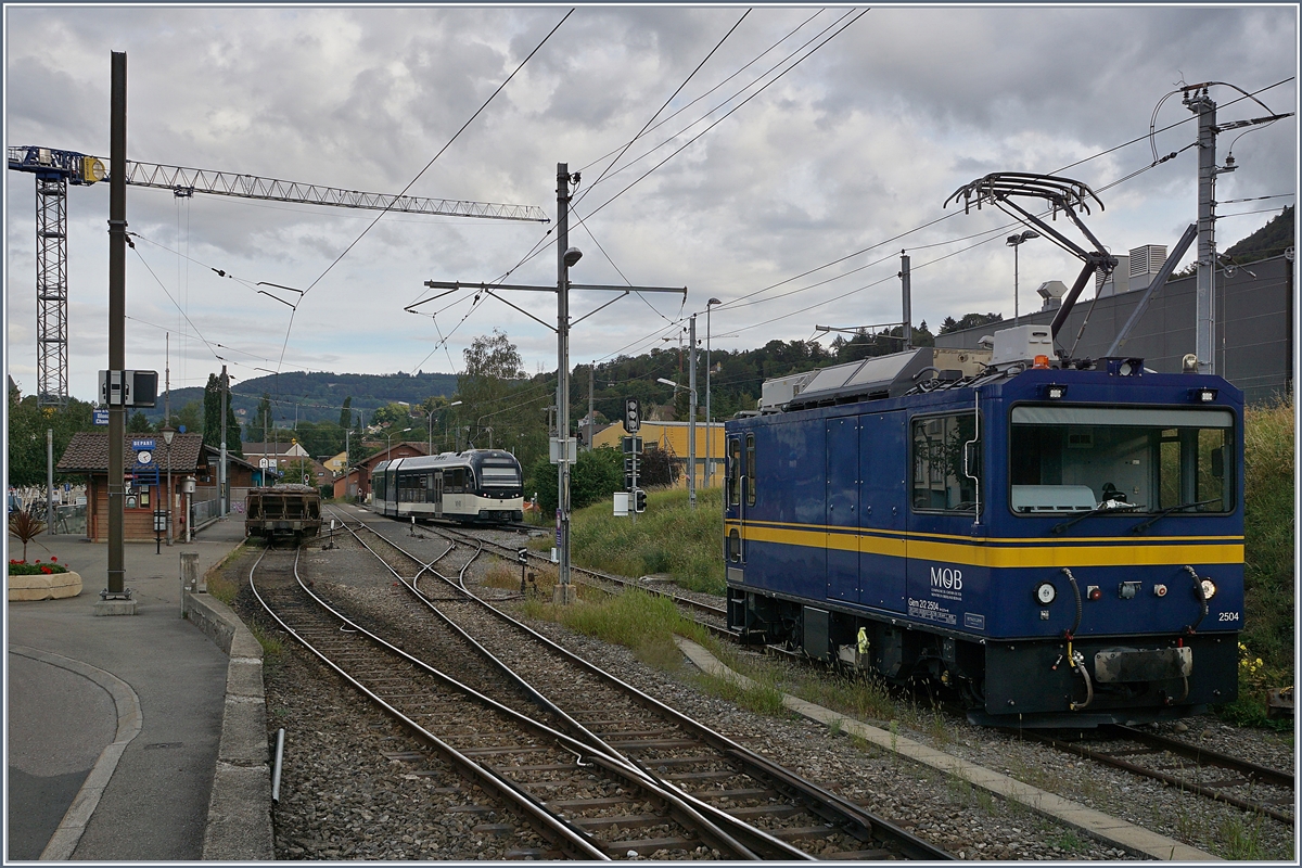 Die MOB Gem 2/2 2504 wartet in Blonay auf einen neuen Einsatz, während im Hintergrund ein MVR ABeh 2/6 von Les Pléiades kommend einfährt.

26. Aug. 2020