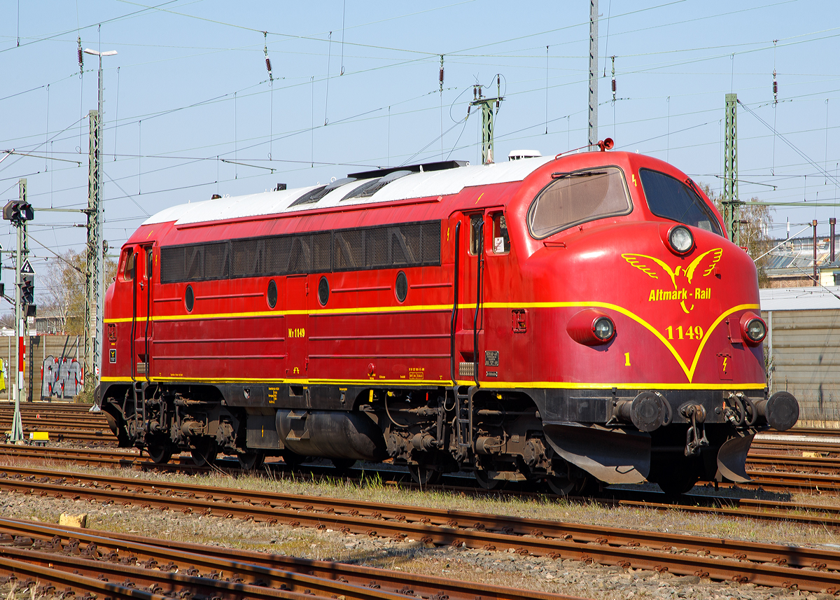 
Die My 1149 eine NOHAB  AA16 der Altmark-Rail (92 80 1227 008-0 D-AMR) auch als V 170 1149 bekannt, ex DSB My 1149, ist am 11.08.2016 beim Bahnhof Troisdorf abgestellt.

Die Lok wurde 1965 von Nydqvist och Holm AB (NoHAB) unter der Fabriknummer 2600 gebaut.

Dreh- und Angelpunkt der Entwicklung in Europa war der schwedische Maschinen- und Lokbauer „Nydqvist och Holm AB“ (NoHAB) in Trollhättan, der 1949 die Lizenzen zum Bau von EMD-Dieselloks erhielt. Dieser überarbeitete die Konstruktion einer an die australische Victoria Railways gelieferten Lok, wobei das engere UIC-Umgrenzungsprofil eine wesentliche Rolle spielte. Besonders das niedrige Lichtraumprofil der SNCF in Frankreich war dabei maßgeblich. Tatsächlich wurde das belgische Pendant (SNCB Reihen 52 bis 53, ex 202 bis 204) der AA16 vor Schnellzügen und TEE-Zügen zwischen Brüssel und Paris eingesetzt.

Als erste Staatsbahn beschaffte die Dänische Staatsbahn DSB (Danske Statsbaner) Lokomotiven von NOHAB. Die ersten vier dieselelektrischen Loks wurden bereits 1952 bestellt, obwohl die Loks nur auf dem Papier existierten. Im Frühjahr 1954 erfolgte die Auslieferung von NOHAB als MY 1101 bis 1104. Die Beschaffung von Loks aus Übersee war heftig umstritten und so wurde der DSB-Haus-und-Hof-Lieferant Frichs aus Aarhus in die Lieferung mit einbezogen. Frichs lieferte die Lokkästen und Drehgestelle ab MY 1102 NOHAB zu. Die Loks der ersten Kleinserie erhielten den 16-Zylinder-Motor Typ GM 16-567 B, der nur eine Leistung von 1.700 PS hatte. Die MY 1101 wurde als erste NOHAB-Rundnase überhaupt am 07.02.1954 an die DSB ausgeliefert.

Noch im Jahr 1954 bestellte die DSB eine zweite Serie von 20 weiteren Loks, die ab 1956 als MY 1105 bis 1124 ausgeliefert wurden. Ab der MY 1106 wurden dann Motoren des Typs GM 16-567 C mit 1.950 PS verbaut. Neben der Leistung erhöhte sich bei diesen Loks das Gewicht von 98,6 auf 101,6 Tonnen.

1956 wurde die dritte Serie bestellt, die ab 1957 als 1125 bis 1144 geliefert wurden. Erst ab 1964 folgten als vierte und letzte Lieferserie die MY 1145 bis 1159, die den verbesserten Motor GM 16-567 D1 mit ebenfalls 1.950 PS erhielten. Diese Loks unterscheiden sich auch optisch von den vorhergehenden Bauserien durch einen anderen Schalldämpfer, dem sogenannten Rillenauspuff. 

Die 6-achsigen Loks der Baureihe MY/MV besitzen für den Einsatz im dänischen Flachland nur vier angetriebene Achsen mit der Achsfolge (A1A)'(A1A)', was sie von allen anderen NOHAB- und AFB-Rundnasen unterscheidet, die sechs Achsen angetrieben haben (Achsfolge Co'Co'). Lediglich die NSB übernahm drei Loks mit je vier Fahrmotoren, die NOHAB ursprünglich ohne Auftrag für die finnischen Eisenbahnen gebaut hatte, ohne sie dorthin verkaufen zu können. Trotz nur vier Fahrmotoren konnten die MY mit ca. 17 Tonnen Achslast nicht auf den dänischen Nebenbahnen eingesetzt werden. Aus diesem Grund beschaffte ab 1960 die DSB 45 Loks als Baureihe MX. Diese MX-Loks bekamen 12-Zylinder-Motoren. Die erste Serie bekam den Motortyp GM 12-567 C mit 1.425 PS und die zweite den Typ GM 12-567 D1 mit 1.445 PS. Mit einem Dienstgewicht von nur noch 89 Tonnen und einer Achslast von 16 Tonnen konnten die MX auf allen DSB-Strecken eingesetzt werden.

Um die Jahreswende 1998-1999 wurden zehn DSB MYs für den Export nach Deutschland aufgearbeitet. In Deutschland gingen die Loks zunächst an die Vossloh-Tochter EuroTrac, wo die eigentliche Vorbereitung auf die neuen Aufgaben stattfand. Die Lok bekamen u.a. neue Heizkessel mit einer Leistung von 400 kW und neue Schneepflüge nachgerüstet (die dänischen Schneepflüge waren für das deutsche Lichtraumprofil zu breit). Die MYs wurden in Deutschland als V 170 bezeichnet, die DSB-Betriebsnummern wurden einfach beibehalten. Die zehn V 170 wurden anfänglich im Auftrag der EuroTrac von der NEG eingesetzt und vermarktet. Daran schloss sich eine verwirrend vielfältige Einsatzgeschichte mit wechselnden Eigentümern und einer Unzahl verschiedener Leiheinsätze an.

Bei dem (General Motors) GM-Dieselmotor handelte es sich um den V16-Zylinder-Zweitakt-Dieselmotor mit Roots-Lader, ab MY 1145, vom Typ GM 16-567 D1. Dieser hat wie allen EMD 567-Motore einen Zylinderdurchmesser von 8 1/2 Zoll (216 mm) und ein Hub von 10 Zoll (254 mm), was zu einem Hubraum von 567 Kubikzoll pro Zylinder, entsprechend 9.292 cm³, führte. Aus diesem Wert leitet sich die Bezeichnung der Baureihe ab. Mit 835 U/min und einer Verdichtung von 20:1 hat der Motor eine Leistung von 1.433 kW (1.950 PS).

Die Idee, einen 2-Takt-Diesel zu verwenden war theoretisch gut, denn ein 2-Takter erbringt (rechnerisch !) bei gleichem Hubraum die doppelte Leistung eines 4-Takt-Motors, hat also große Gewichtsvorteile und braucht weniger Platz. - In der Praxis ist dies jedoch relativ. Bauteile müssen stärker dimensioniert werden, die großen Gebläse (meist Rootsgebläse) und deren Antrieb sind schwer und brauchen einigen Platz. Zudem nutzt der 2-Takt-Motor den Kraftstoff schlechter aus, er  säuft .  Außerdem ist ein 2-Takt-Diesel sehr laut, fast kreischend, daher auch der typische Sound dieser Lokomotiven.

TECHNISCHE DATEN:
Anzahl: 59 	
Hersteller: NOHAB / GM 
Spurweite: 1.435 mm (Normalspur)
Achsfolge 	(Ao1Ao)' (Ao1Ao)' 	
Länge über Puffer : 18.900 mm 	
Höhe: 4.295 mm
Breite: 3.080 mm
Drehzapfenabstand: 10.300 mm
Drehgestellachsstand:  3.400 mm
Treibraddurchmesser: 	1.015 mm
Laufraddurchmesser: 	950 mm
Dienstgewicht: 101,6 t 	
Motor: GM type 567D1, 16 Zylinder, Zweitakt-Dieselmotor
Hubraum: 148,67 Liter
Leistung: 1.433 kW (1.950 PS) bei 835 U/min
Tankinhalt:  2.800 l
Anzahl der Fahrmotoren: 4
Kraftübertragung: dieselelektrisch (Dieselmotor auf Generator, dieser liefert dann die elektrische Energie für die 4 Fahrmotoren)	
Höchstgeschwindigkeit : 133 km/h 	
Kupplungstyp:  Schraubenkupplung
