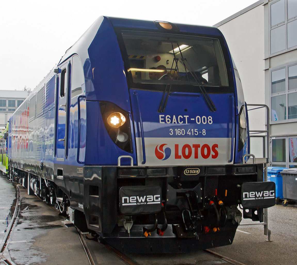 Die Newag Dragon E6ACT - 008 (91 51 3 160 415-8  PL-LOTOS) der Lotos Kolej ausgestellt auf der Inno Trans 2014 in Berlin (hier 26.09.2014). 

Dieser DRAGON (Drache) wurde 2014 von Newag Gliwice (ehemals ZNLE Gliwice - Zakłady Naprawcze Lokomotyw Elektrycznych S.A., geg�ndet 1899 als K�nigliche Eisenbahn – Lokomotivwerkst�tte) unter der Fabriknummer E6ACT-008 gebaut und an die Lotos Kolej Sp. z o.o. in Gdańsk (Danzig) ausgeliefert, zudem wurde sie auf der InnoTrans 2014 in Berlin pr�sentiert. 

Die Newag E6ACT Dragon ist eine in Polen entwickelte und gebaute Elektrolokomotive f�r den Personen- sowie schweren G�terverkehr des Herstellers Newag. Bislang wurden neun Maschinen gebaut und ausgeliefert, alle neun Loks werden nur auf dem polnischen Gleichstromnetz eingesetzt. 

Die E6ACT hat die Achsfolge Co'Co' und ist mit 6 asynchronen Fahrmotoren ausger�stet. Die Maschinen wurde f�r das polnische 3 kV Gleichstrom entwickelt und wird mittlerweile auch als Diesel- sowie Dreisystemvariante angeboten,  diese fanden bislang aber noch keinen Abnehmer. Sie verf�gt �ber eine Wirbelstrombremse sowie ein mechanisches Bremssystem. Sie ist mit einem computergest�tztem Steuerungs- und Diagnosesystem ausger�stet. Der Lokkasten wurde als selbsttragende Schwei�konstruktion ausgef�hrt.
Die Hauptvorteile des DRAGON ist die sehr hohe Zugkraft mit einem Wert von 374 kN, die im Zusammenhang mit dem Lokomotivgewicht von 119 t, einem modernen Anti-Blockier-System und einem Einzelantrieb f�r jede Achse, erm�glichen es, G�terz�ge mit einem Gewicht bis zu 4.500 t zu ziehen. Mit einer Achslast von unter 20t t, kombiniert mit einer speziell entwickelten Federung, f�hren zu der Tatsache, dass der DRAGON perfekt angepasst ist f�r schwierigen Betriebsbedingungen und um effektiv im polnischen Eisenbahnnetz zu arbeiten.

Technische Daten:
Spurweite:  1.435 mm (Normalspur)
Achsformel:  Co' Co'
L�nge �ber Puffer:  20.330 mm 
Breite: 3.000 mm
H�he: 4.325 mm
Dienstgewicht:  119 t 
Achslast: 19.6 t
H�chstgeschwindigkeit:  120 km/h (Konstruktiv 140 km/h)
Dauerleistung:  5.000 kW
Anfahrzugkraft:  374 kN (450 kN mit der Option Max Last)
Stromsystem:  3 kV DC (Gleichstrom)
Anzahl der Fahrmotoren:  6  mit je 834 kW Leistung
Triebraddurchmesser: 1.250 mm (neu) / 1.170 mm (abgenutzt)
Lichtraumprofil: UIC 505-1