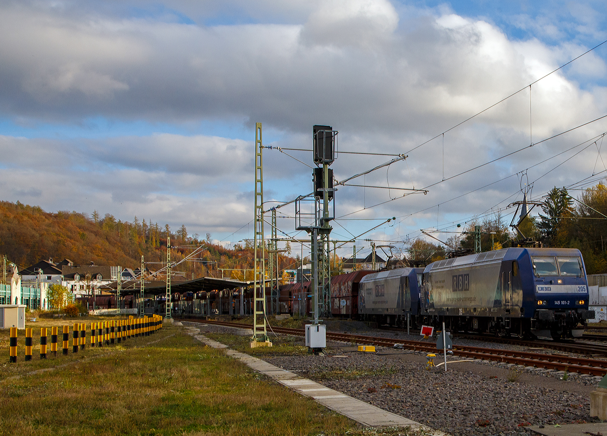 Die RBH 205 bzw. RBH 145 101-2 (91 80 6145 101-2 D-RBH) und RBH 218 (an die RBH vermietete DB 145 027-9 (91 80 6145 027-9 D-DB)) fahren am 06.11.2021 in Doppeltraktion einen Kohlenzug (offene Schüttgutwagen der Gattung Falns) durch den Bf. Betzdorf (Sieg) in Richtung Köln.

Vorne die RBH 145 101-2 wurde 2001 von Bombardier in Kassel unter der Fabriknummer 33849 gebaut und an die RBH. Die 145 027-9 wurde 1999 von ABB Daimler-Benz Transportation GmbH (Adtranz) in Kassel unter der Fabriknummer 33344 gebaut und an die DB geliefert, seit Sommer 2018 ist sie an die RBH Logistics GmbH in Gladbeck vermietet.

Die RBH Logistics ist ein Tochterunternehmen der DB Cargo Deutschland AG und die Nachfolgegesellschaft von Werks-, Zechen- und Hafenbahnen im Raum der Bergwerksdirektion Recklinghausen. Durch die verschiedenen Firmenzusammenschlüsse und -aufteilungen ergab sich seit 1913 eine wechselvolle Geschichte. Das heute als Teil des Firmennamens genutzte Akronym RBH stand einige Jahre für die RAG-Bahn- und Hafenbetriebe und wurde beim Verkauf von dieser an die Railion Deutschland im Jahr 2005 beibehalten. Nach damaliger Angabe des neuen Eigentümers stehen die Buchstaben R, B und H nun für die Kernkompetenzen des Unternehmens: Eisenbahnverkehr (Rail), Binnenschifffahrt (Barge) und Hafenumschlag (Harbour).
