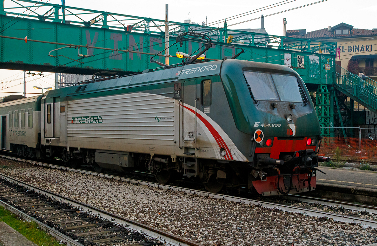 Die rechtsaubere Trenord E.464.255 (91 83 2464 255-5 I-TN), eine Bombardier TRAXX P160 DCP, am 29.12.2015  mit einem Nahverkehrszug im Bahnhof Milano Porta Genova (Stazione di Milano Porta Genova).

Die Lok wurde 2009 Bombardier im Werk Vado Ligure (I) unter der Fabriknummer 7829 gebaut.

Die Baureihe E.464 ist eine Elektrolokomotive, die ab 1999 von ADtranz (heute Bombardier) von der italienischen Staatsbahn Ferrovie dello Stato (Trenitalia), der Ferrovie Emilia Romagna (FER) sowie der Trasporto Ferroviario Toscano (TFT) beschafft wurde. Gefertigt werden die Lokomotiven im Bombardier-Werk in Vado Ligure unter der firmeninternen Bezeichnung TRAXX P160 DCP. Gebaut wurden bisher 728 Einheiten dieser Baureihe.

Da die Maschinen ausschließlich mit Wendezügen eingesetzt werden, verfügen sie auch nur über einen Führerstand. Am anderen Ende befindet sich ein Mehrzweck-/Gepäckabteil, ein Hilfsführerstand für Rangierfahrten sowie ein Wagenübergang mit Gummiwulst. In Italien werden die Maschinen als „locomotiva monocabina“ (Lokomotive mit nur einem Führerstand) bezeichnet. Die Baureihe E.464 verwendet Drehgestelle und Getriebe ähnlich denjenigen der DB Baureihe 101, der Antrieb erfolgt aber mit Doppelstern-Asynchron-Fahrmotoren.
Am Führerstandsende sind die Loks mit einer automatischen Scharfenbergkupplung ausgerüstet. Auf der zum Wagenzug hingewandten Seite sind herkömmliche Zug-/Stoßeinrichtungen mit Schraubenkupplung. 

TECHNISCHE DATEN:
Spurweite: 1.435 mm (Normalspur)
Achsfolge: Bo' Bo' 
Hersteller:  Bombardier (vorm. ADtranz)
Länge über Puffer: 15.930 mm
Dienstgewicht: 72 t
Dauerleistung: 3.000 kW (2.350 kW bei 1.500 V DC)
Anfahrzugkraft: 200 kN
Dauerzugkraft: 135 kN
Stromsystem: 3.000 V und 1.500 V DC (Gleichstrom)
Anzahl der Fahrmotoren: 4 
Getriebeübersetzung: 1 : 5,015
Höchstgeschwindigkeit: 160 km/h