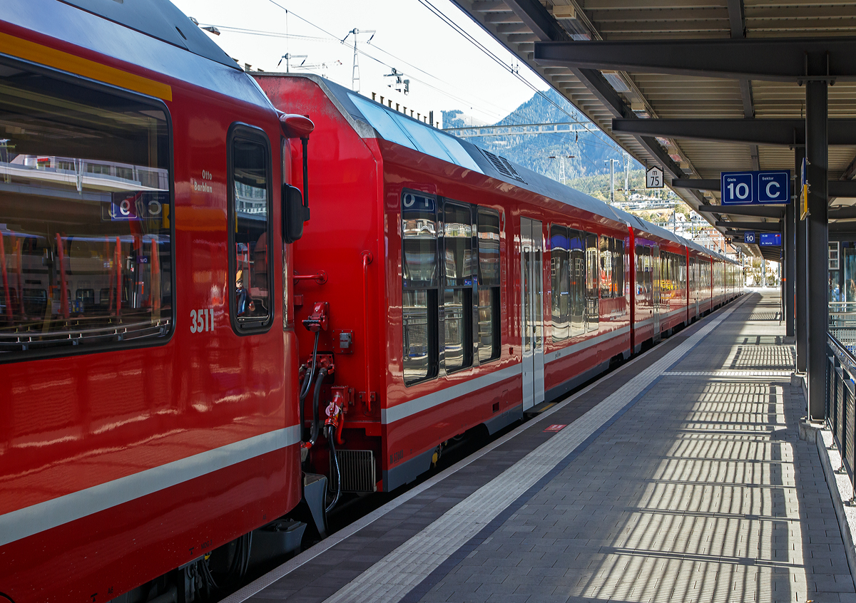 Die Rh�tischen Bahn (RhB) hat auch an uns Fotografen gedacht, denn die RhB Alvra-Gliederz�ge haben ein Fotoabteil mit Senkfenstern.
Der 3511 (RhB ABe 8/12) steht mit dem RhB Alvra-Gliederzug bzw. Albula-Gliederzug AGZ ABi 5703 (Alvra ist r�toromanisch f�r Albula) am 01.11.2019 als IR nach St. Moritz im Bahnhof Chur zur Abfahrt bereit.

Als Alvra (R�toromanisch f�r Albula) werden bei der Rh�tischen Bahn (RhB) die ab 2015 beschafften, siebenteiligen Gliederz�ge mit den Betriebsnummern 5701 bis 5706 bezeichnet. Die Garnituren werden zwischen Chur und St. Moritz �ber die Bahnstrecke Landquart–Thusis und die Albulabahn eingesetzt, von Chur nach St. Moritz werden sie von Lokomotiven der Reihe Ge 4/4 III oder von den ALLEGRA-Zweispannungstriebz�gen der Reihe ABe 8/12 gezogen und in die andere Richtung geschoben. Die von Stadler Rail gebauten sechs siebenteiligen Wagenz�ge inklusive Steuerwagen geh�ren zur Qualit�tsoffensive der RhB. Die ersten Alvra wurden 2016 noch ohne Steuerwagen in Betrieb genommen.

Der Albula-Gliederzug ABi 5703  besteht aus folgenden Wagen:

-	Endgliedwagen Bi 57603 (hier vorne im Bild) mit 41 Pl�tze 2. Klasse, 2 
Rollstuhlpl�tze 2. Klasse, 3 Klappsitze, Niederflurbereich, Behindertengerechtes WC und Fotoabteil mit Senkfenster. Sechs elektrische Panorama-Senkfenster (leider etwas langsam) und Dachfenster mit manuell verstellbaren Sonnenstoren und eine Sitzbank mit 14 einzeln abklappbaren Sitzpl�tzen sorgen im Fotoabteil f�r ein v�llig neues Bahnerlebnis. 

-	Gliedwagen B 57403 mit 64 Sitzpl�tzen in der 2. Klasse und Platz f�r 1 Fahrrad und Kinderwagen, kein WC.

-	Gliedwagen B 57303 mit 64 Sitzpl�tzen in der 2. Klasse und Platz f�r 1 Fahrrad und Kinderwagen, kein WC.

-	Gliedwagen B 57703 (Familien- und Freizeitwagen) mit 32 Sitzpl�tzen in der 2. Klasse, 14 Klappsitze und 10 Fahrr�der und Kinderwagen, zwei Standard-WCs, Kinderspielecke und Multifunktionsraum.

-	Gliedwagen AB 57203 mit 29 Sitzpl�tzen in der 1. Klasse, 16 Sitzpl�tzen in der 2. Klasse und Platz f�r 1 Fahrrad und Kinderwagen, kein WC.

-	Endgliedwagen A 57003  mit 34 Sitzpl�tzen in der 1. Klasse, Platz f�r 1 Fahrrad und Kinderwagen und zwei Standard-WCs

-	Steuerwagen Ait 57803 mit 27 Sitzpl�tzen in der 1. Klasse, Platz f�r 1 Fahrrad und Kinderwagen und zwei Standard-WCs, Behindertengerechtes WC, Niederflurbereich

Mit den Alvra-Gliederz�gen beschaffte die Rh�tische Bahn f�r 124 Millionen Schweizer Franken sechs Zugkompositionen, welche das Erscheinungsbild der B�ndner Gebirgsbahn weiter modernisieren.

TECHNISCHE DATEN der AGZ einschl. Ait 578 : 
Nummerierung:  AGZ ABi 5701 bis 5706
Anzahl:  6
Hersteller:  Stadler Rail
Baujahre:  2015–2017
Spurweite:  1.000 mm (Meterspur)
L�nge �ber Puffer:  131.450 mm
H�he:  
Breite:  2.670 mm
Leergewicht (mit Steuerwagen):  172 t
Sitzpl�tze in der 1. Klasse (inklusive Ait): 90
Sitzpl�tze in der 2. Klasse (inklusive Ait): 217
Rollstuhlpl�tze: 4
Behindertengerechte WCs (UWC in den Niederflurbereichen): 2
Standard-WC (SWC): 4
