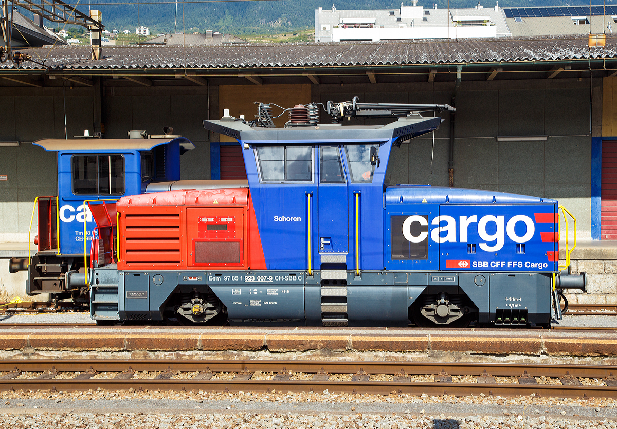 
Die SBB Cargo Eem 923 007-9  Schoren  (Eem 97 85 1 923 007-9 CH-SBB C) abgestellt am 16.09.2017 im Bahnhof Sion (Sitten).

Die Zweifrequenz-Hybridlokomotive vom Typ BUTLER wurde 2012 von Stadler Winterthur unter der Fabriknummer L-11000/007 gebaut. 

SBB Cargo bestellte im Juni 2010 beim Schweizer Fahrzeugbauer Stadler Rail in Winterthur 30 neue Zweifrequenz-Hybridlokomotive Typ Eem 923 001-030 für Güter- und Rangierdienste. Diese Hybridlok ist eine richtige Kompaktlok die unter Fahrleitungsbetrieb 15kV 16,7 Hz sowie 25kV 50 Hz Wechselstrom fahren kann und für die  letzte Meile  dank eines Dieselmotors auch auf nicht elektrifizierten Gleisen ohne Leistungsverminderung ihre Arbeit verrichten kann. Mit einer Leistung von 1500 kW, einer Höchstgeschwindigkeit von 120 Km/h sowie Vielfachsteuerungsmöglichkeit für bis zu 4 Eem 923 ist diese Lok für SBB Cargo ein wahrer Alleskönner. 

Weitere Technische Merkmale sind:
Verschleiß lose elektrische Bremse mit Rückführung der Bremsenergie ins Fahrleitungsnetz (Rekuperation) oder über Bremswiderstände im Dieselbetrieb.
Pneumatische indirekte Bremse für Zug und direkte Bremse für die Lok.
Ein leistungsstarker Schraubenkompressor mit einer Förderleistung
von 2400 Liter/min.

Technische Daten zur Eem 923
Hersteller: Stadlerrail Winterthur
Eigentümer: SBB Cargo
Anzahl der Fahrzeuge:  30
Spurweite:  1.435 mm
Achsformel:  Bo
Länge über Puffer:  9.100 mm
Achsabstand:  4.300 mm
Fahrzeugbreite:  3.100 mm
Fahrzeughöhe:  4.306 mm
Dienstgewicht (Tara)  45 t
Raddurchmesser Neu:  1.100 mm
Maximale Leistung am Rad:  1.500 kW (2040 PS)
Maximale Leistung Dieselmotor:  290 kW (394 PS)
Anfahrzugkraft:  150 kN
Höchstgeschwindigkeit:  120 km/h
Umgrenzungsprofil: UIC 505-I AB-EBV U3
Fahrdrahtspannung:  15kV 16,7 Hz und 25kV 50 Hz Wechselstrom
Zugsicherungsystem:  Signum-ZUB 262ct, ETM-S
Nachrüstungsmöglichkeiten:  ETCS-Level 2 / Indusi
Zugfunksystem:  GSM-R
Auslieferungsjahr:  2012-2013
