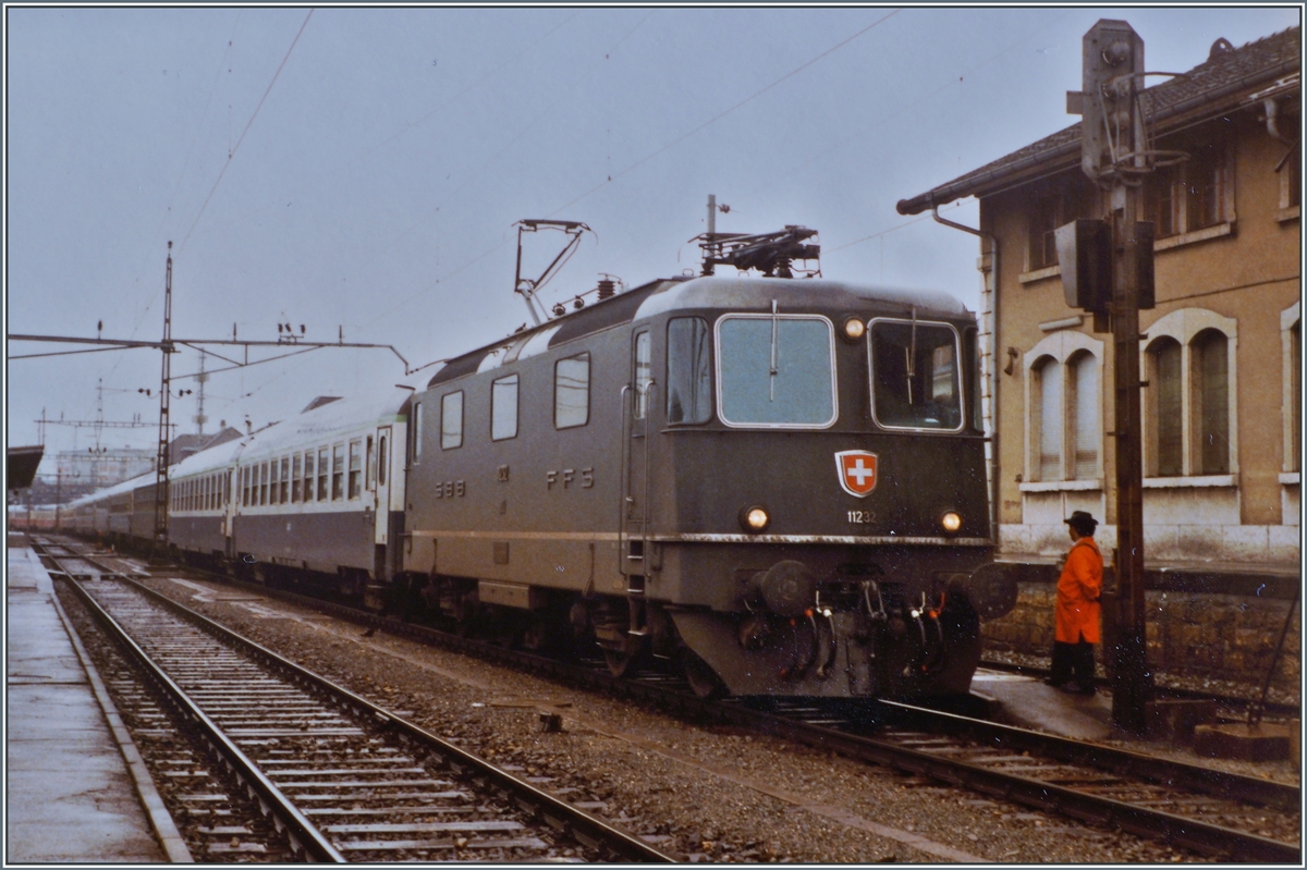 Die SBB Re 4/4 II 11232 wartet nach der �bernahme des Hispania Express nach dem Fahrtrichtungswechsel in Del�mont auf die Weiterfahrt nach Basel. Der Zug besteht aus zwei Teilen: dem IC/EC Hispania von Gen�ve nach Hamburg und dem Nachtzug Port-Bou bzw. Cerb�re - Basel (-Hamburg).

16. Sept. 1984 