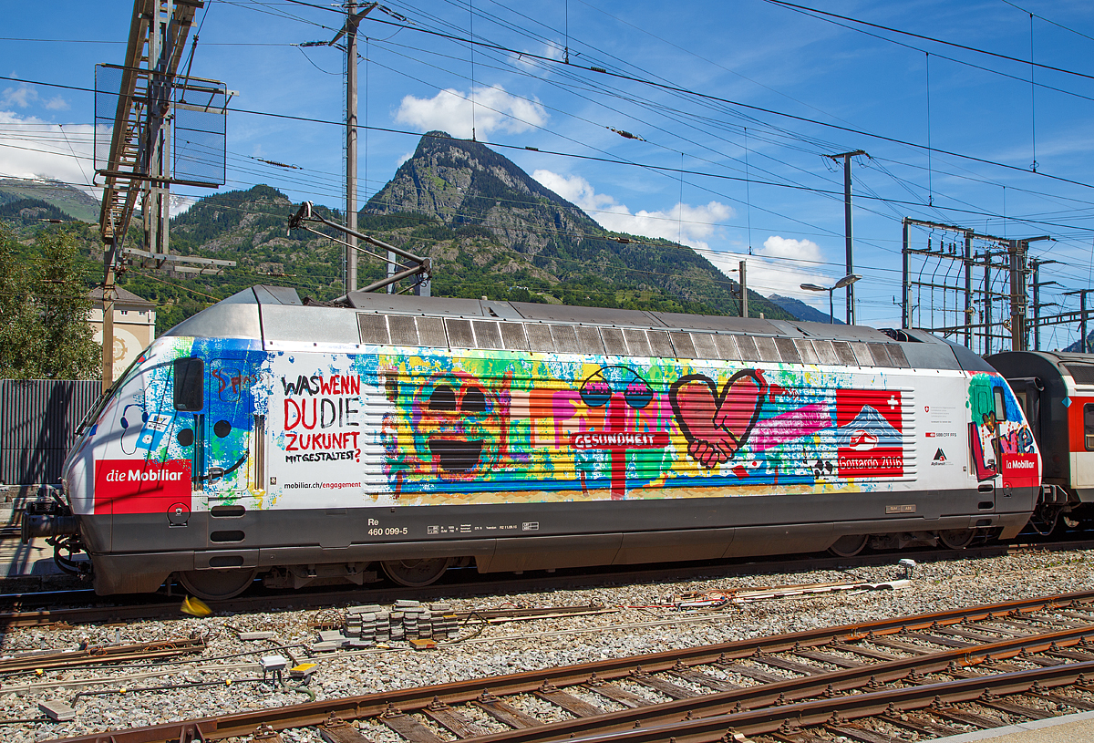 
Die SBB Re 460 099-5 „ Bodensee , Werbelok für die Mobiliar und Gottardo 2016,  am 20.06.2016 im Bahnhof Brig.

Die Lok2000 wurde 1994 von der SLM unter der Fabriknummer 5666 gebaut, der elektrische Teil ist von ABB.

Nun auch mal eine ausführliche Beschreibung zu diesem  Loktyp: 
Die SBB bestellte im Zusammenhang mit den Projekten Bahn 2000 eine erste Serie von 12 Universal-Hochgeschwindigkeitslokomotiven, noch als Re 4/4VI – 10701 bis 10712 bestellt. Diese Bestellung wurde noch vor Beginn der Konstruktionsarbeiten auf 24 erhöht. Für den alpenquerenden Güterverkehr wurde von der Eidgenossenschaft eine weitere Serie von 75 Lokomotiven (auch als 'Hupac'-Lokomotiven bekannt) in Auftrag gegeben. Die vorgegebenen Liefertermine für dieses Los waren derart kurz, dass die SLM an die Kapazitätsgrenze ihrer Werkstätte gelangte. Es wurden deshalb dreißig Lokkasten an Krauss-Maffei in München untervergeben 

Im Hinblick auf die geplante Hochgeschwindigkeitsstrecke wurden nochmals zwanzig Lokomotiven nachbestellt, was die Serie auf 119 ansteigen ließ. Die im Volksmund Lok 2000 genannte Lokomotive hat eine Höchstgeschwindigkeit von 230 km/h und eine Leistung von 6,1 MW und ist für den Schnellzugs- wie Güterverkehr ausgelegt. Um die Gesamtmasse von 84 Tonnen nicht zu überschreiten musste ein gesickter Leichtbaukasten konstruiert werden, dessen Form vom Designstudio Pininfarina entworfen wurde.

Um auf den Strecken durch die Alpen den Radverschleiß gering zu halten, haben die Lokomotive radial einstellbare Achsen erhalten. Auch auf dem Gebiet der elektrischen Ausrüstung wurde Neuland beschritten. Zwei Ebenen Steuerelektronik für das Fahrzeug und den Antrieb sind eingebaut. Über das Fahrzeugleitgerät wurden zu viele Elemente gesteuert, wie Scheibenwischer oder Signalhorn. Dies führte anfänglich zu vielen Störungen und oft blieben Lokomotiven auf der Strecke liegen. Erst die Verbesserung der Programmierung erlaubte es die Zuverlässigkeit so zu erhöhen, dass es kaum mehr zu Ausfällen führte. Als Feststellbremse wurden in den Drehgestellen Permanentmagnetschienenbremsen eingebaut. Auch hier gab es am Anfang übermäßig viele Störungen und die Lokomotiven klebten regelmäßig an den Schienen fest.

Um den Schiebedienst auf den Gebirgsstrecken weniger personalaufwendig durchzuführen, wurden mehrere Lokomotiven mit einer amerikanischen Funkfernsteuerung ausgerüstet und als Ref 460 bezeichnet. Damit konnte von der Zugspitze aus eine am Zugschluss eingesetzte Lokomotive ferngesteuert werden. Die Divisionalisierung der SBB erlaubte es nicht mehr groß davon zu profitieren, denn alle Lokomotiven wurden dem Personenverkehr zugeteilt und der Einsatz vor Güterzügen war somit beendet.

Die Re 460 blieb nicht ein Einzelstück und entwickelte sich zu einer Lokomotivfamilie. Eine erste Bestellung wurde von der BLS für acht Lokomotiven gemacht. Die BLS Re 465 hat im Gegensatz zur Re 460 vier statt zwei Stromrichter. Jeder Motor hat dadurch seine eigene Regelung um die Eigenschaften im Bergeinsatz zu verbessern. Weiter können die BLS-Lokomotiven mit allen gängigen Schweizer Lokomotiven in Vielfachsteuerung verkehren. Das erlaubte es bei der BLS den Lokomotiveinsatz flexibler zu gestalten. Die SBB bestellte ebenfalls zehn Re 465, die bei Ablieferung schon das blaue BLS-Design hatten, aber erst später von der BLS übernommen wurden. Nach Finnland konnten auch in zwei Serien Lok 2000 verkauft werden. Dort sind sie als Sr2 bezeichnet. Nach Versuchsfahrten in Norwegen im schwierigen Winterdienst bestellten die NSB die fast baugleichen Lokomotive EL18 2241 bis 2262. Eine letzte Lieferung umfasst zwei Lokomotiven für Hongkong. Sie werden an jedem Ende eines Doppelstockzuges eingesetzt. Dies sind die letzten von SLM in Winterthur gebauten Fahrzeuge. Die Re 460 ist bis auf weiteres die letzte Vollbahn-Streckenlokomotive, die komplett von schweizerischen Unternehmen konstruiert und gebaut wurde. Der Lokomotivbau in der Schweiz wurde inzwischen aus wirtschaftlichen Gründen eingestellt. Einzig Stadler Rail stellt in der Schweiz noch Lokomotiven für den Rangier- und für den Zahnradbetrieb her.

TECHNISCHE DATEN der Re 460:
Nummerierung: 	Re 460 000–118
Anzahl: 119
Baujahre: 1991–1996
Spurweite: 1.435 mm
Achsformel: Bo'Bo'
Länge über Puffer:  18.500 mm
Höhe:  4.300 mm
Breite:  3.000 mm
Achsabstand im Drehgestell:  2.800 mm
Dienstgewicht: 	84,0 t
Höchstgeschwindigkeit:  200 km/h (zugelassen)  / 230 km/h (technisch möglich) 
Dauerleistung: 	6.100 kW (8300 PS)
Anfahrzugkraft: 	300 kN
Dauerzugkraft: 	100 kN
Laufraddurchmesser: 	1.110 mm
